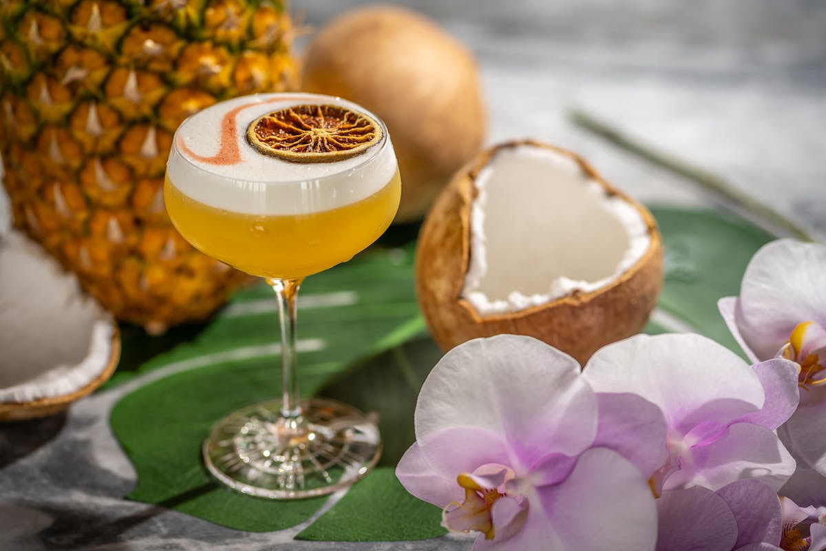 a cocktail and a coconut on a table