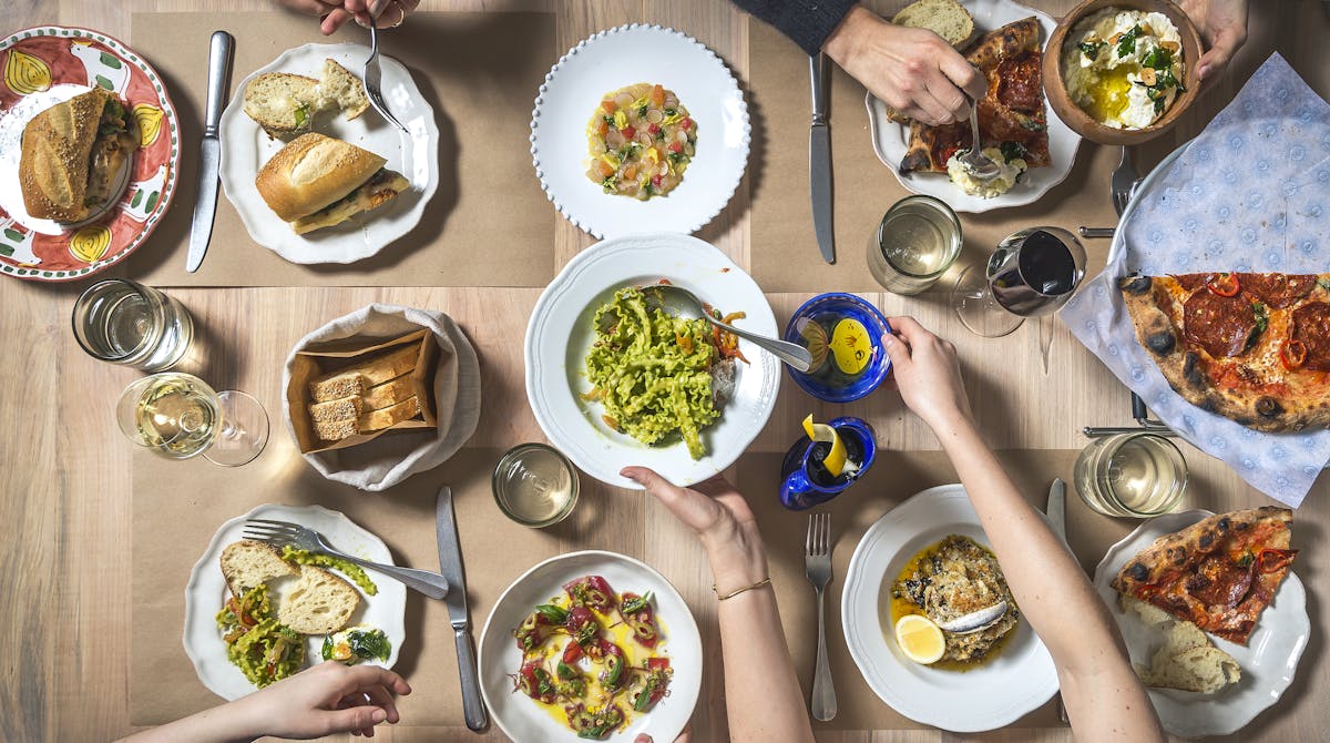 a group of people sitting at a table with a plate of food