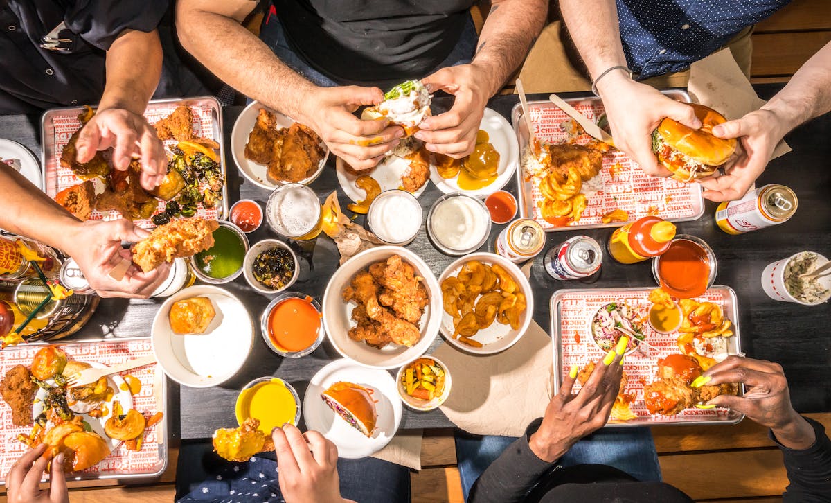 a group of people sitting at a table with food