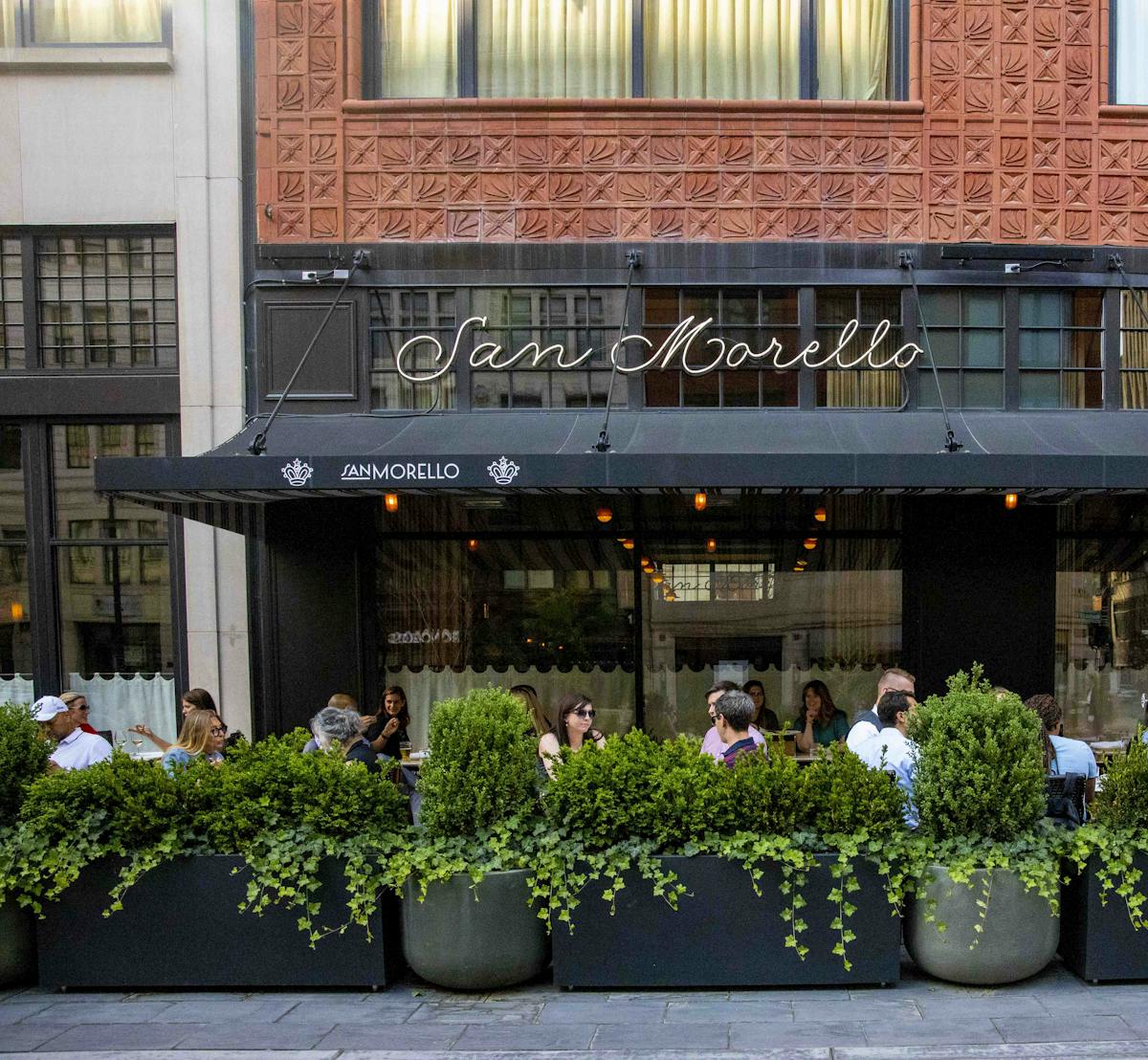 a group of people sitting in front of a brick building