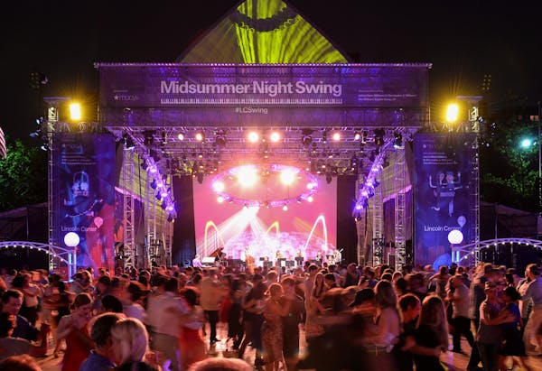 a group of people on a stage with a crowd watching