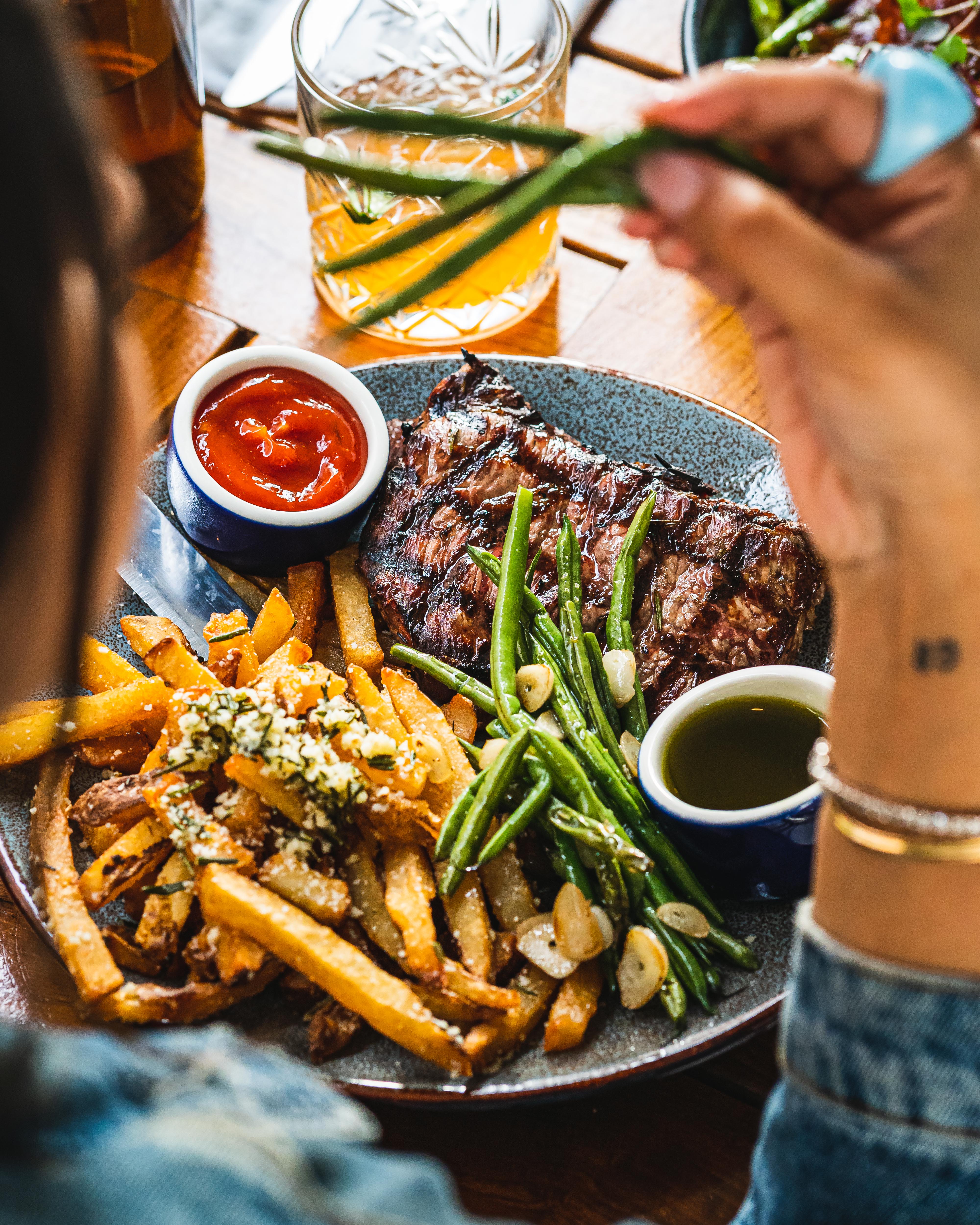 a person sitting at a table with a plate of food