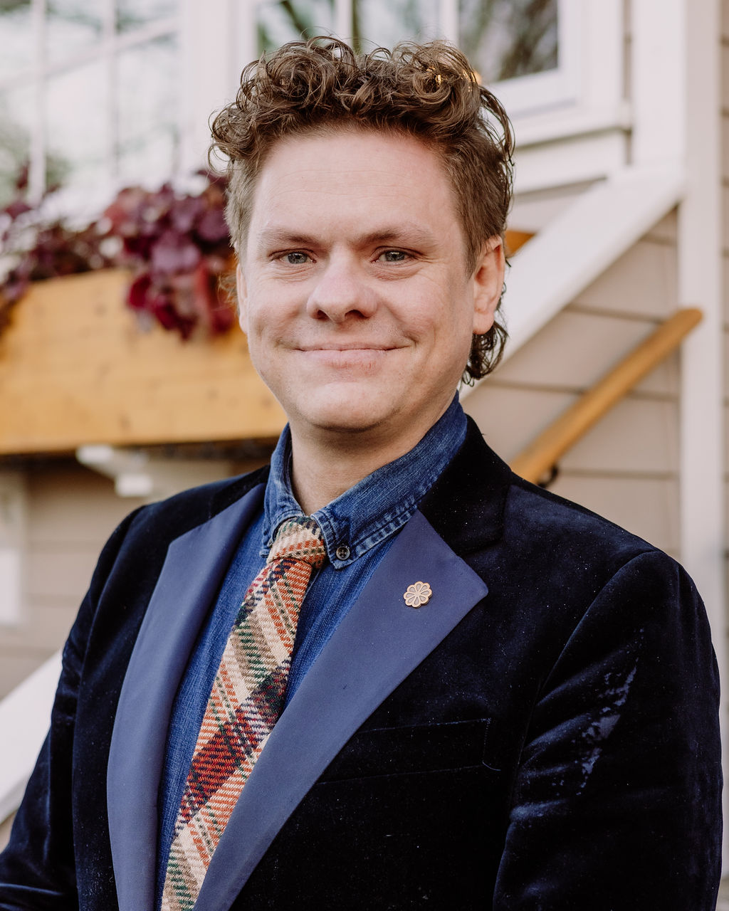 a man wearing a suit and tie smiling at the camera