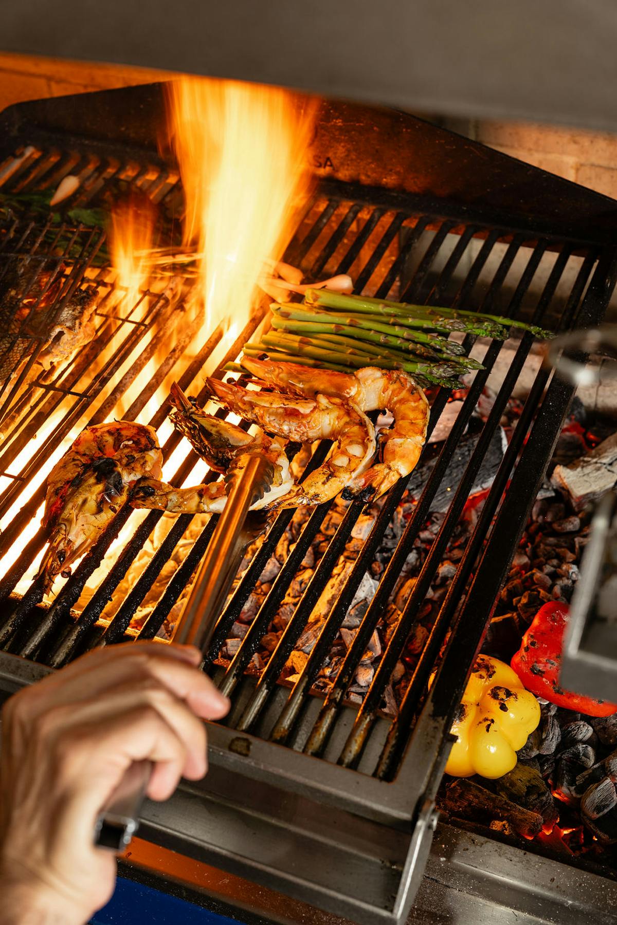 a person cooking hot dogs on a grill