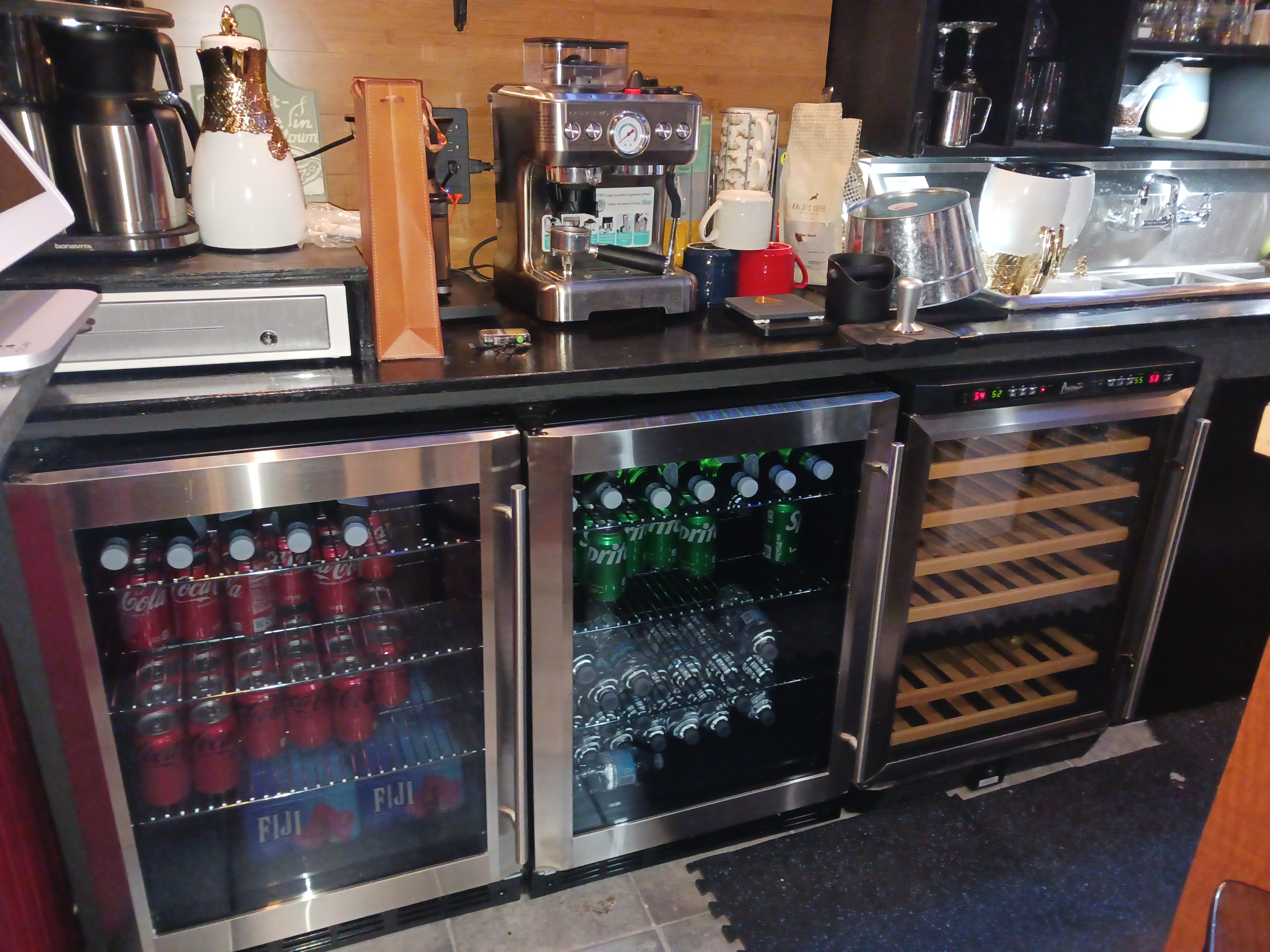 A modern kitchen featuring a sleek refrigerator and a stylish bar area, showcasing contemporary design elements