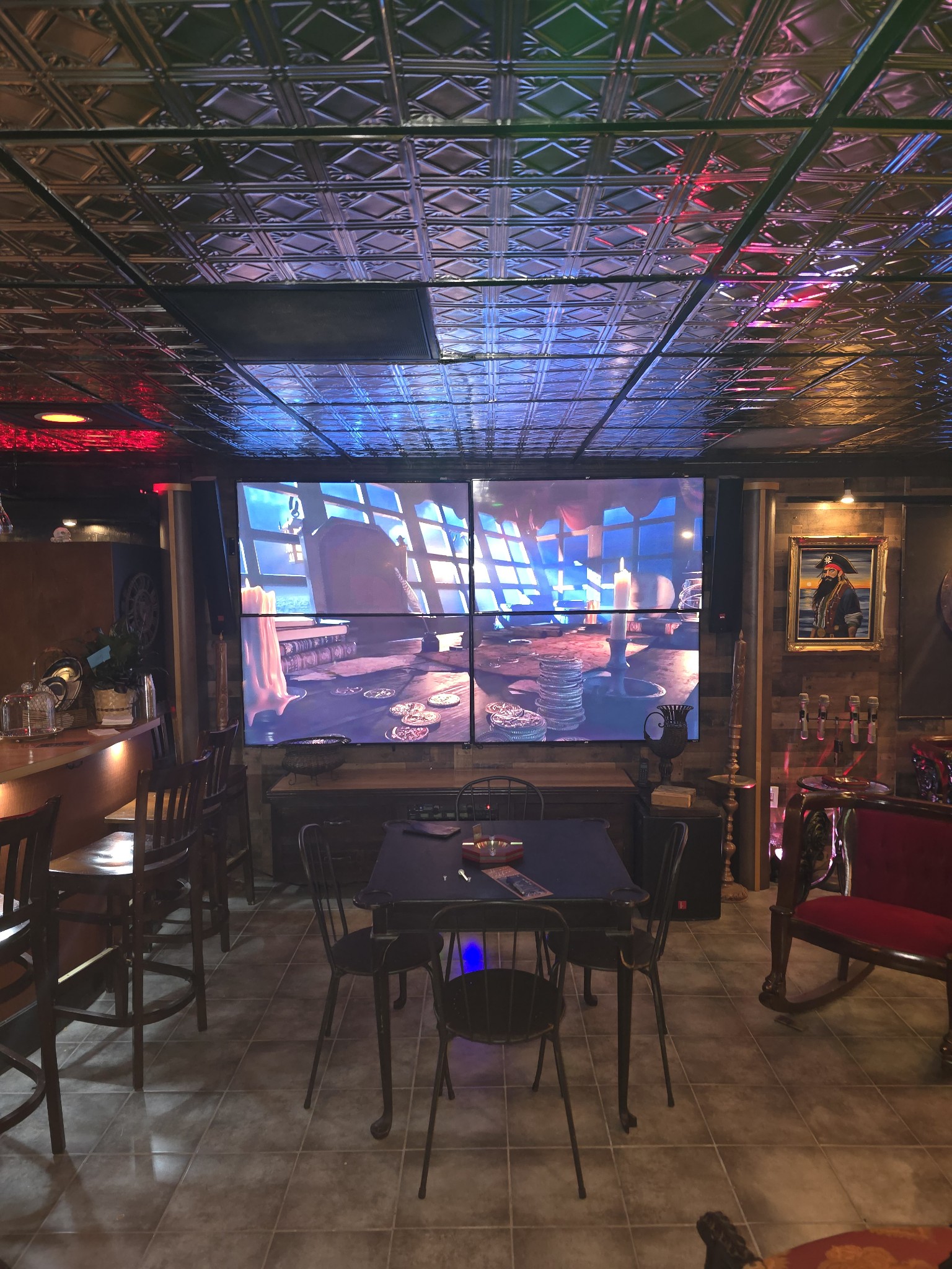 A stylish room featuring a bar area and a large projector screen for presentations or entertainment
