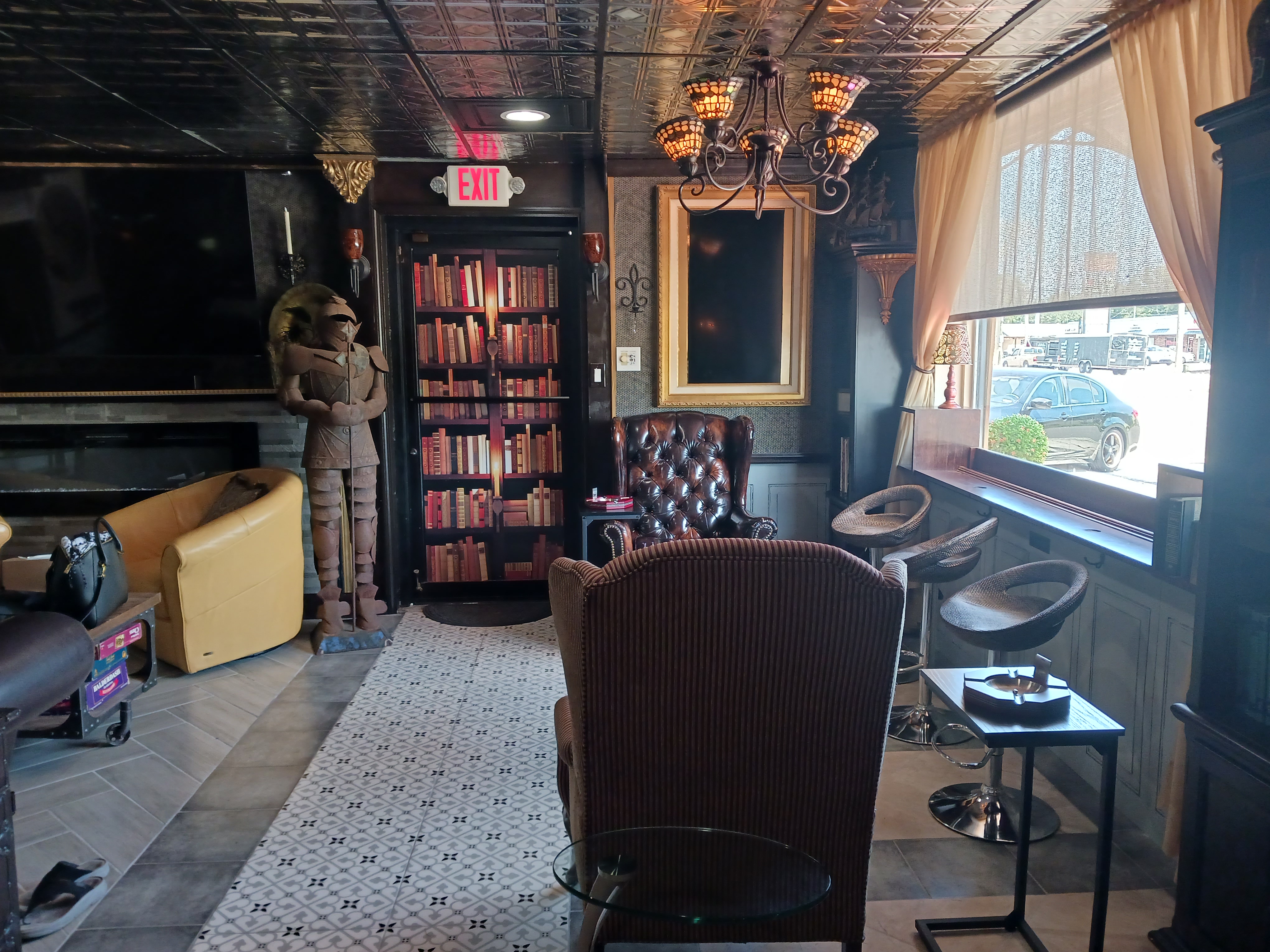 A cozy room featuring a fireplace, comfortable chairs, and a well-stocked bookcase, inviting relaxation and reading