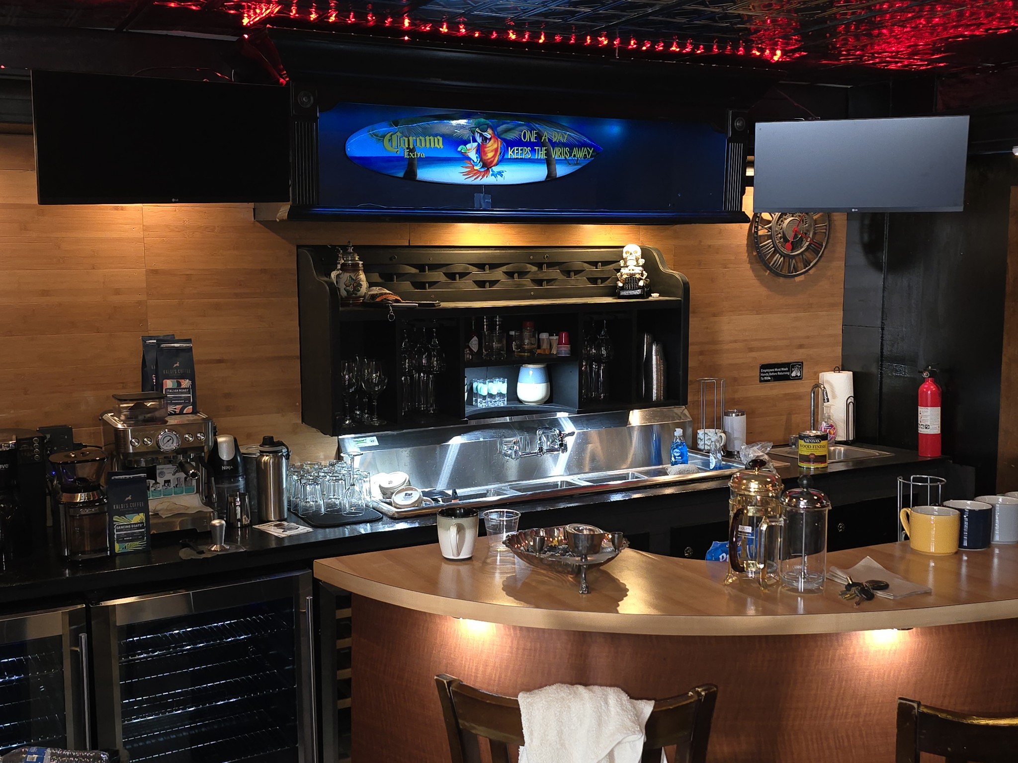A lively bar featuring a television mounted on the wall above a polished bar counter, inviting patrons to relax and enjoy