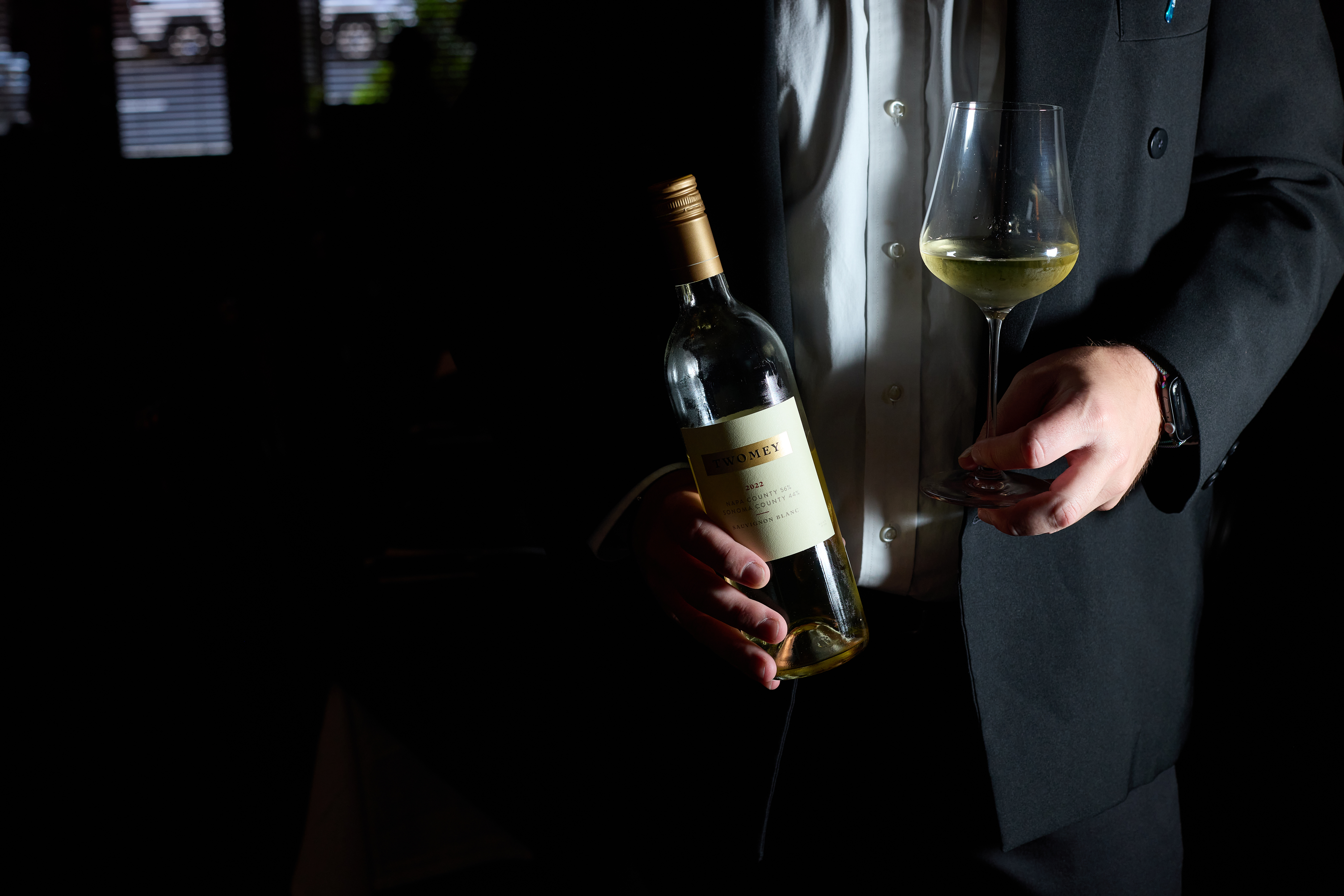 a man holding a bottle of Silver Oak wine and a wine glass