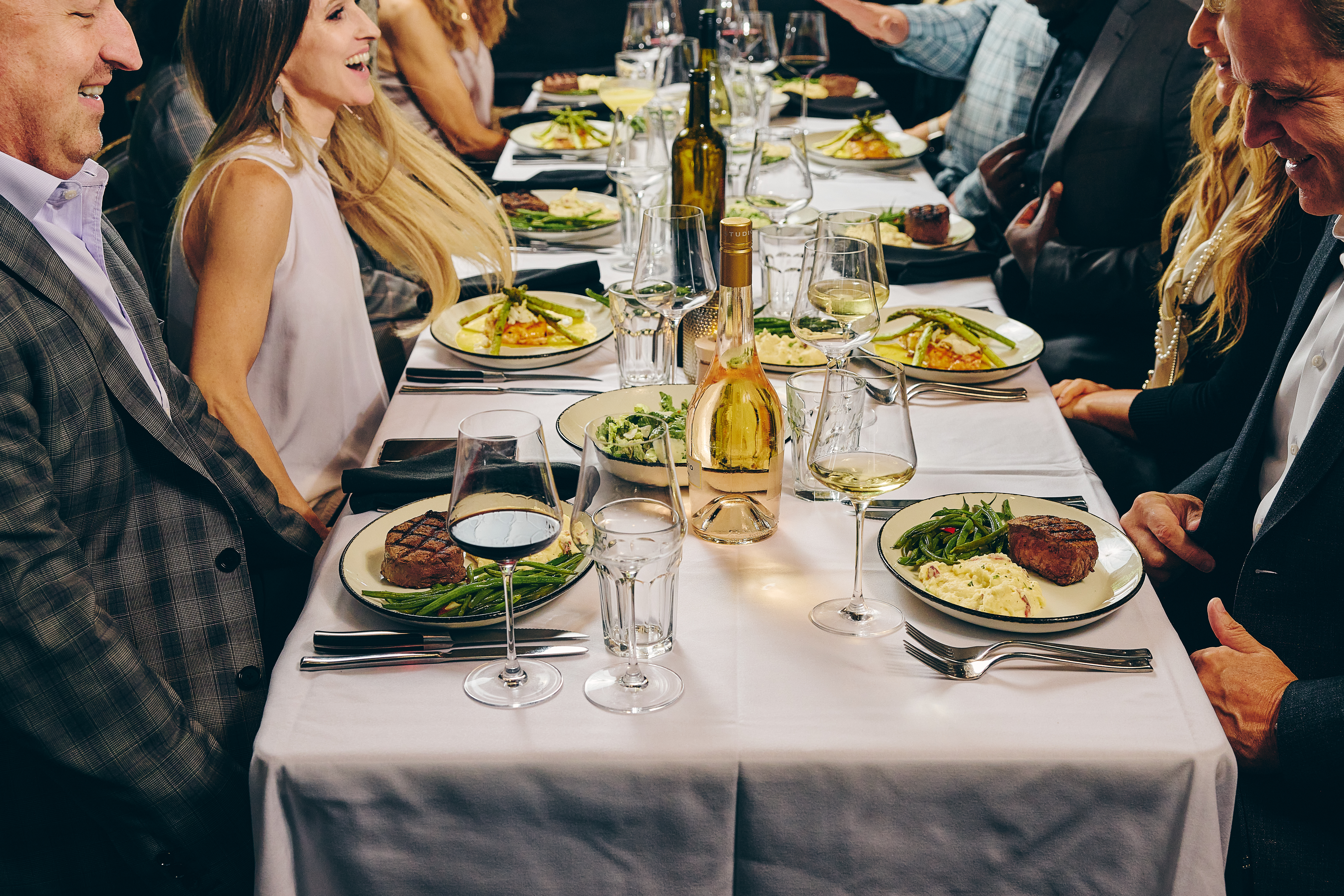 a group of people sitting at a table with plates of food