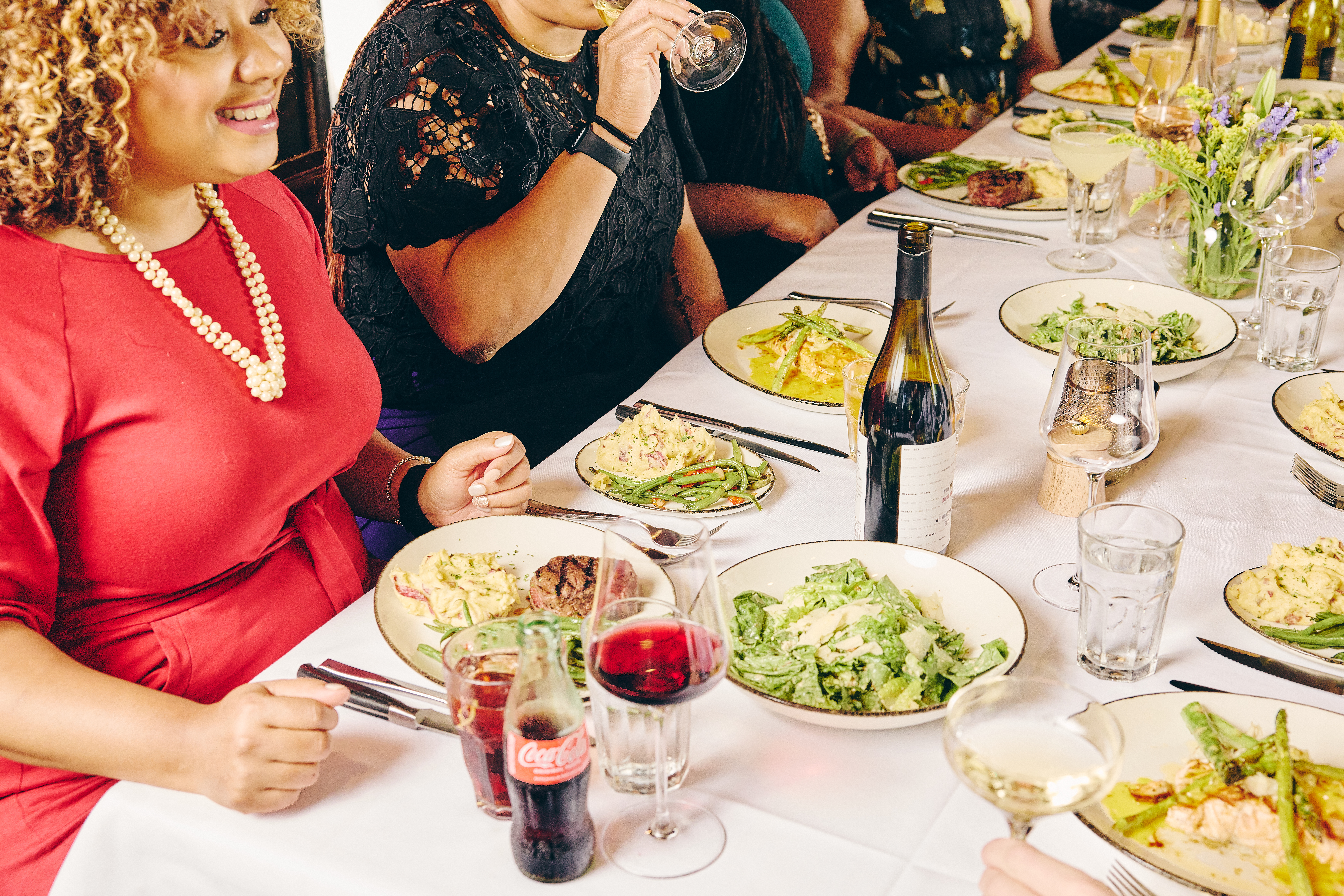 a group of people sitting at a table with plates of food