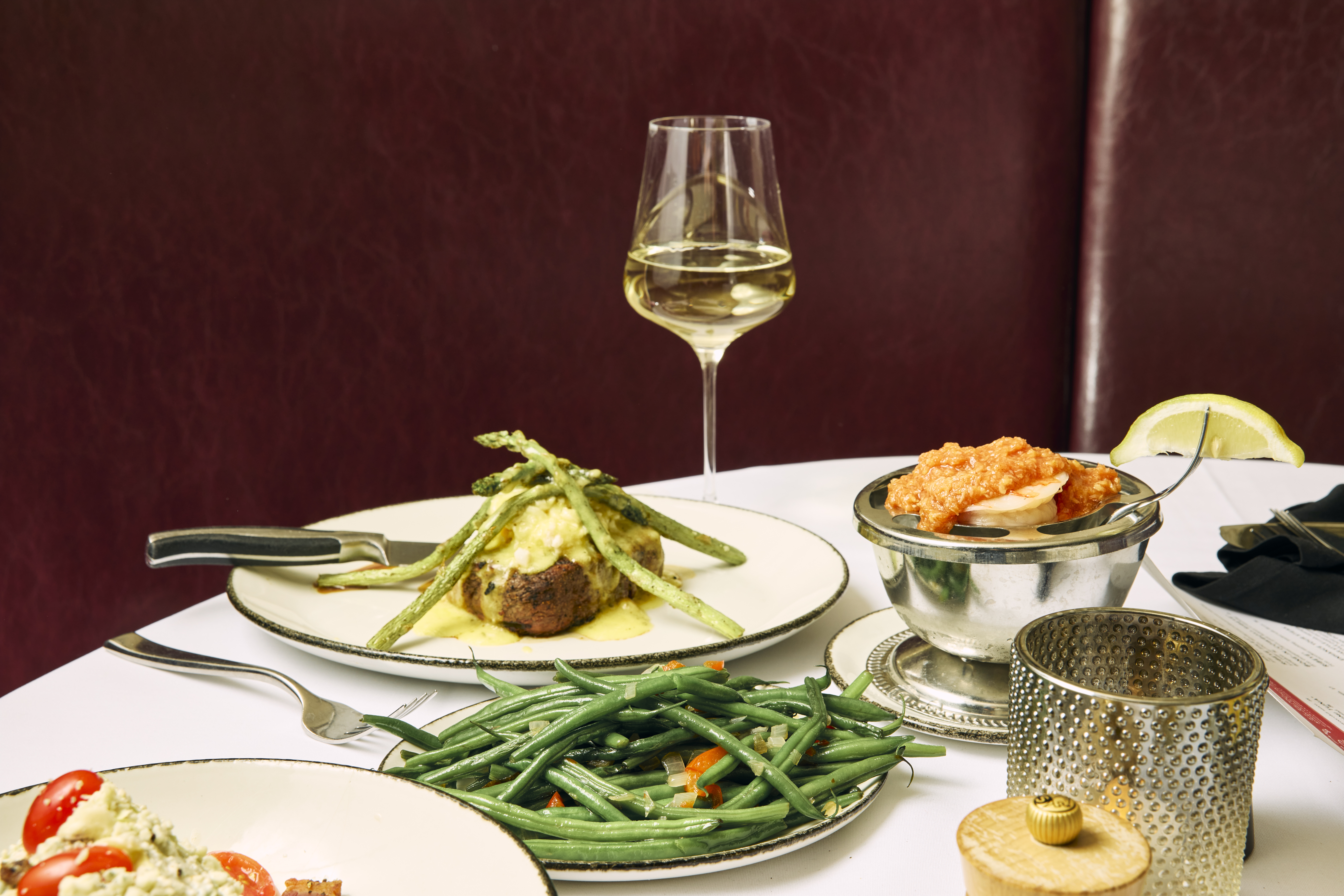 a table with plates of food and a glass of wine