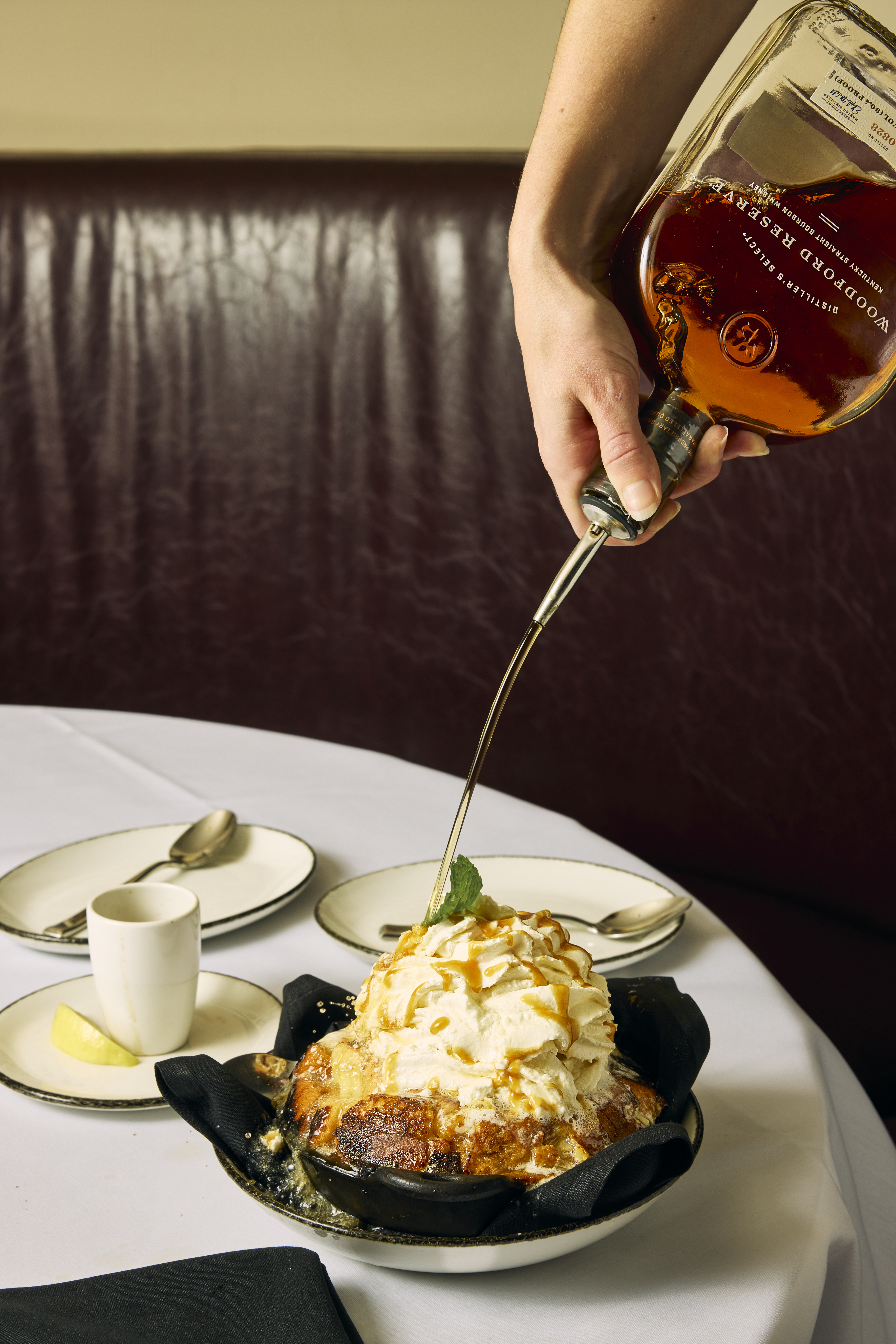 a person pouring liquid onto a dessert