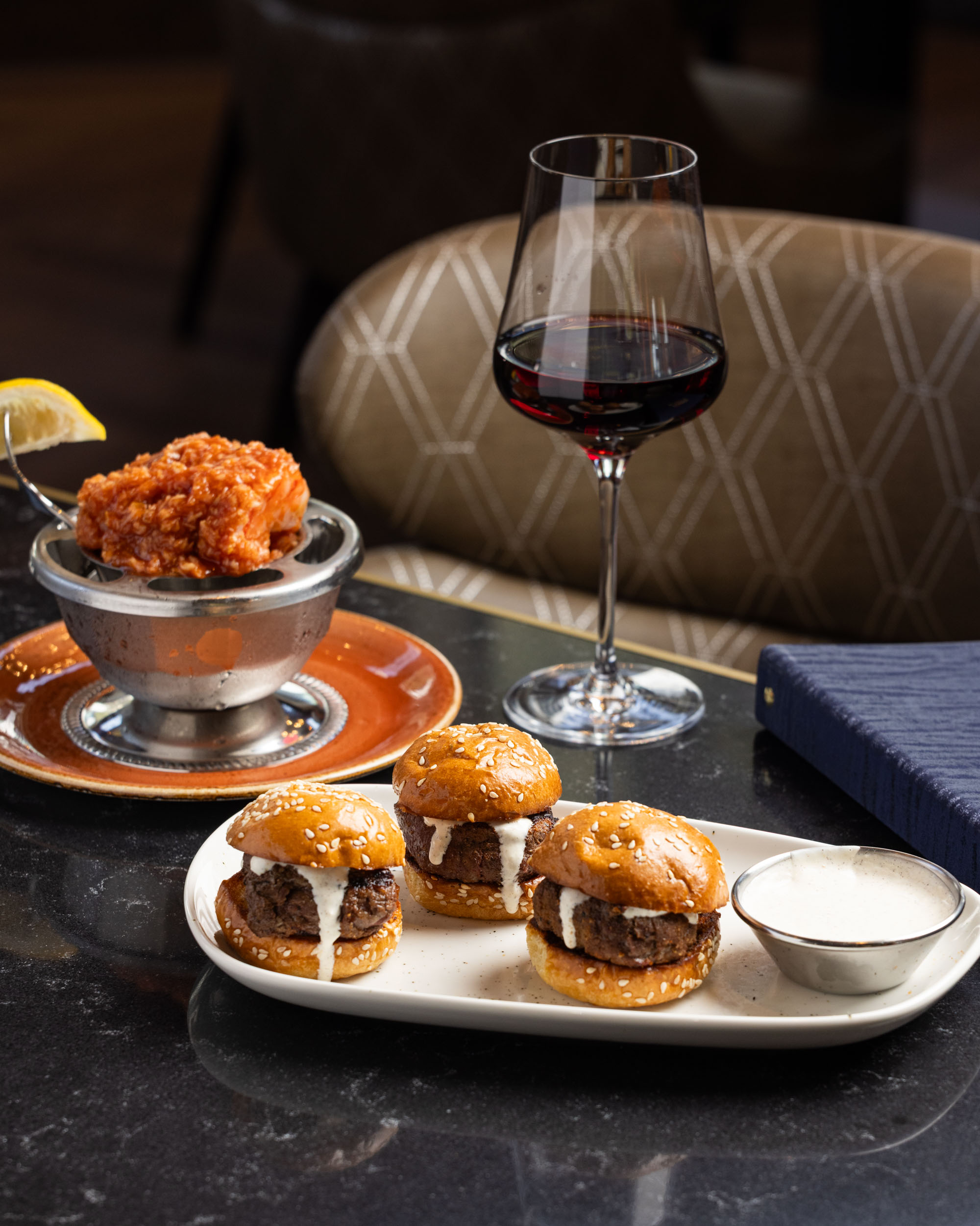 a plate of burgers and a glass of wine