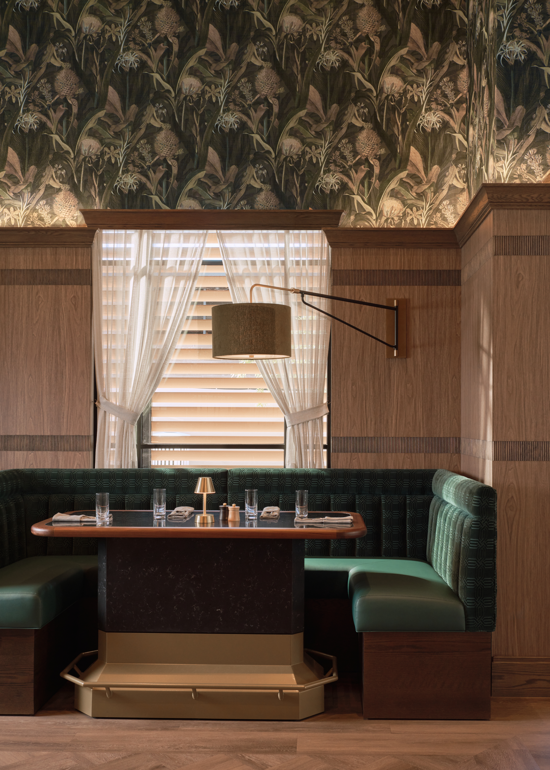 a table with green benches and lamps in a restaurant
