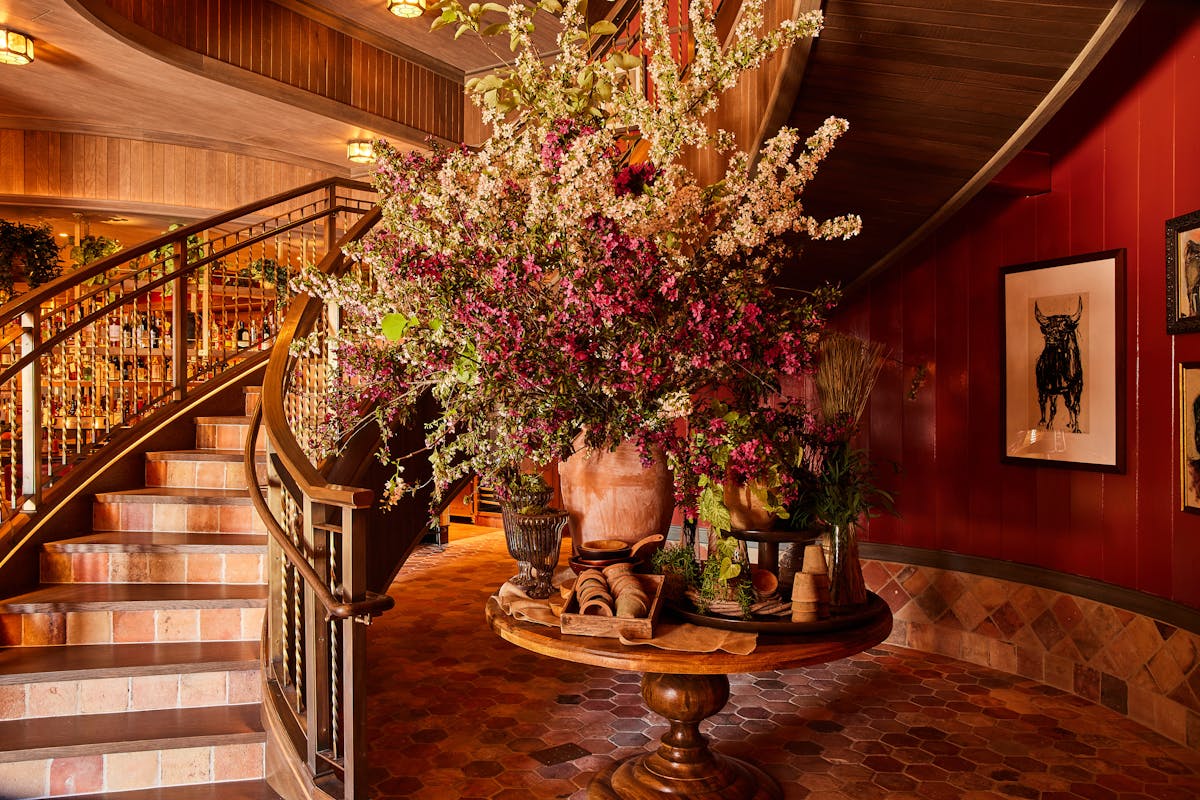 a room filled with furniture and vase of flowers on a brick building