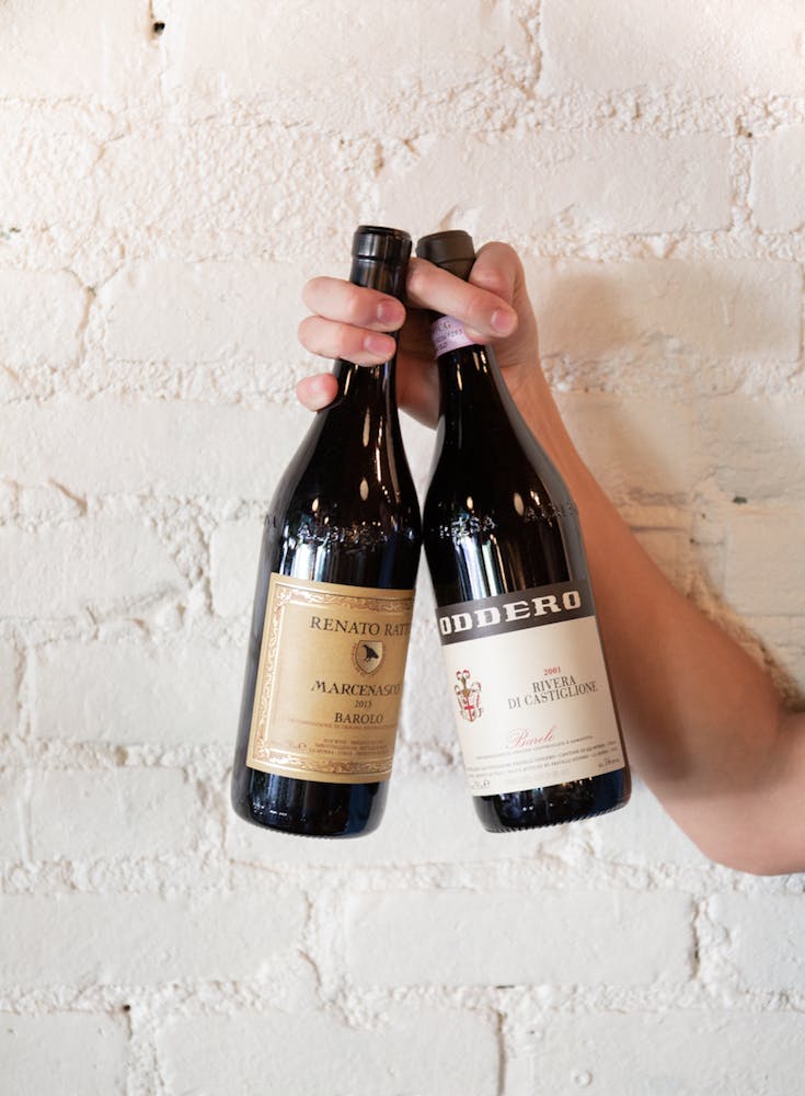 a hand holding a bottle of wine