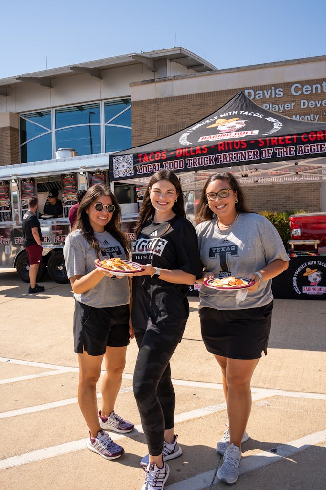 a group of people standing in a parking lot