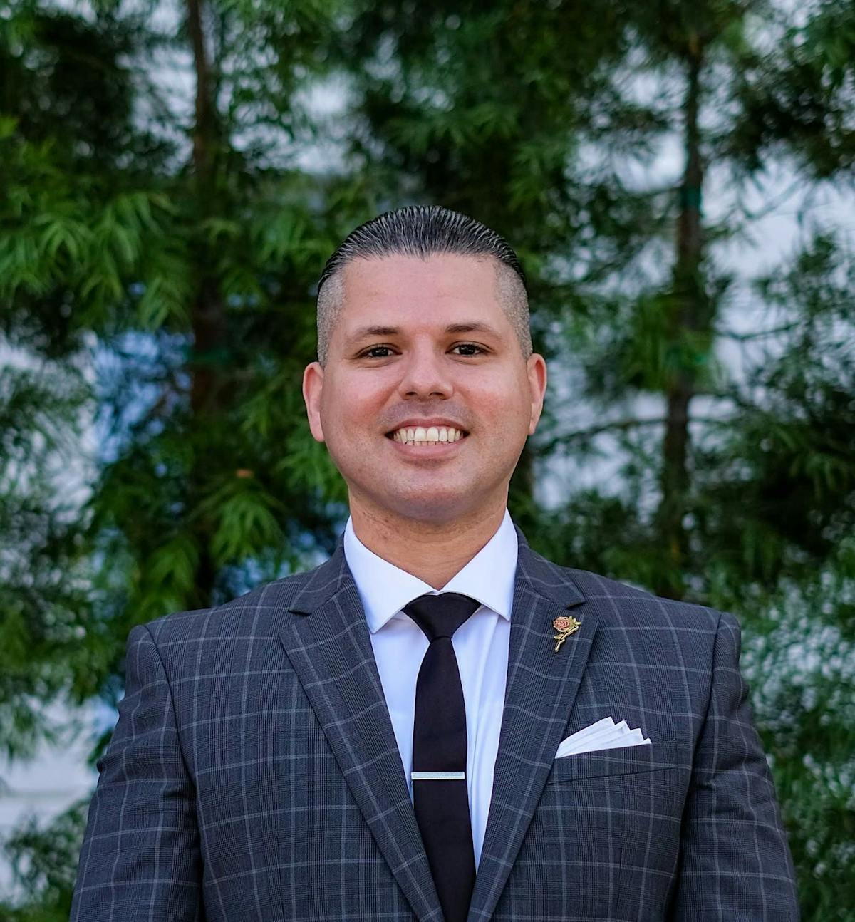 a man wearing a suit and tie smiling at the camera