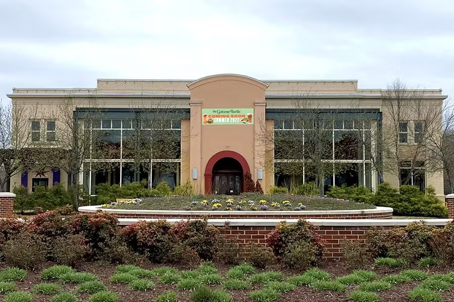 a large brick building with grass in front of a house