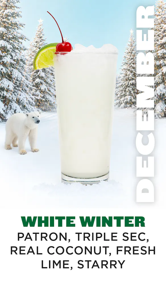 a polar bear standing in the snow next to a glass of milk