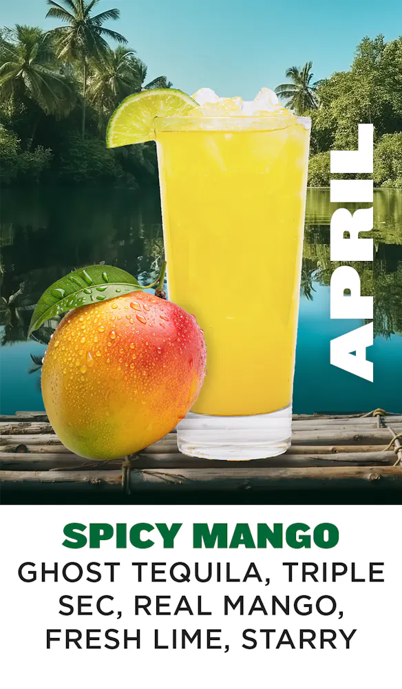 a glass of yellow liquid next to a mango