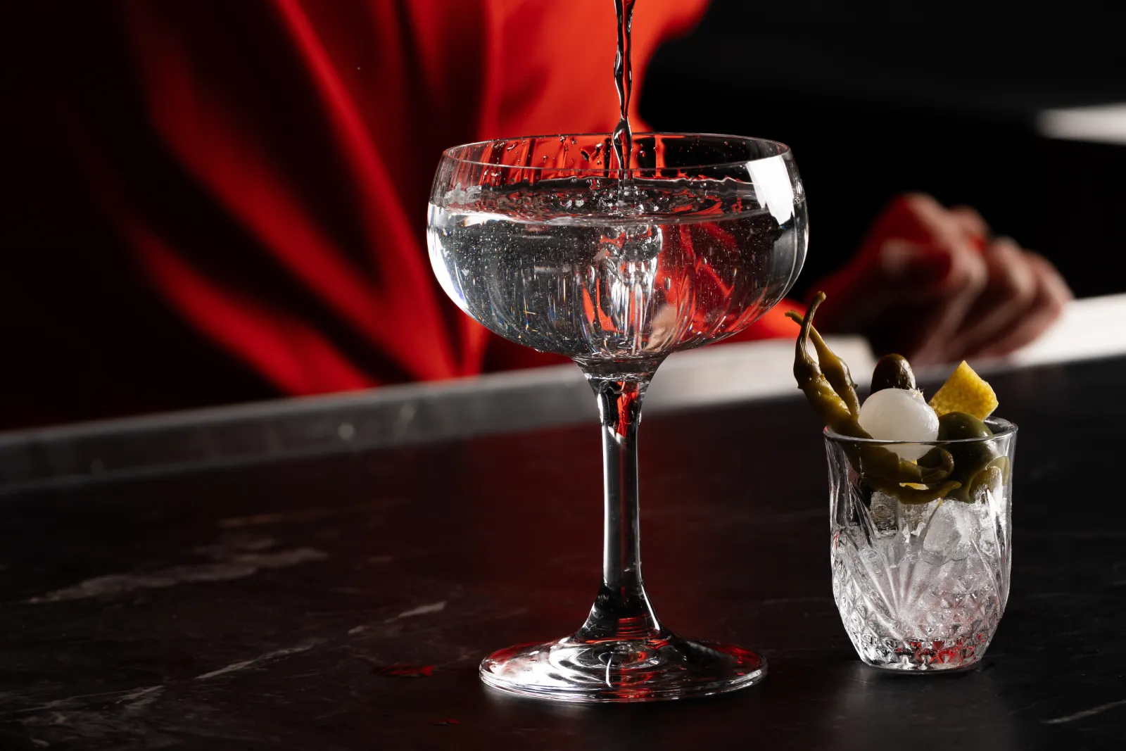 a glass of liquid being poured into a small glass