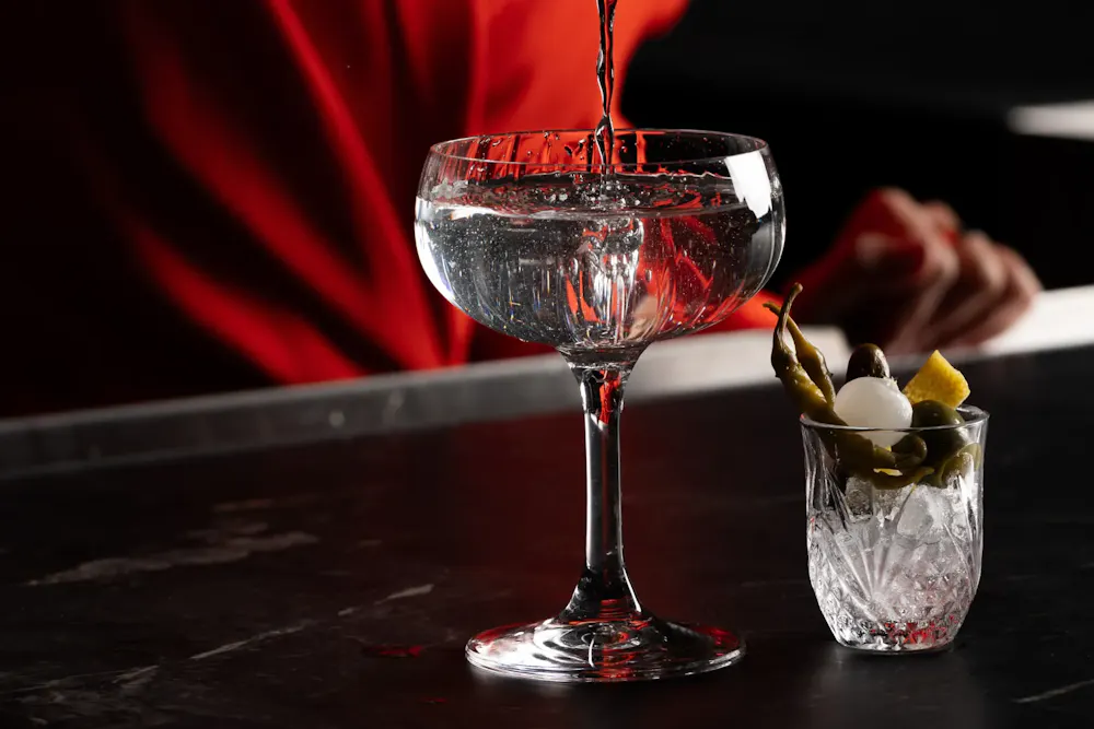 a glass of liquid being poured into a small glass
