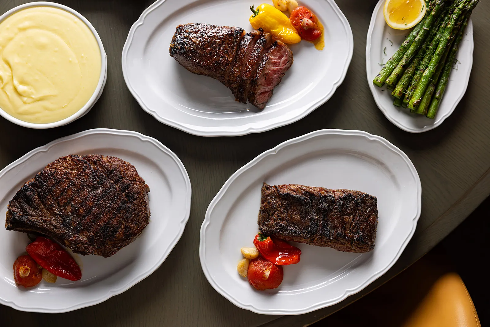 Overhead view of steaks and roasted peppers, asparagus, and mashed potatoes at Vermilion, near downtown Boston parks.