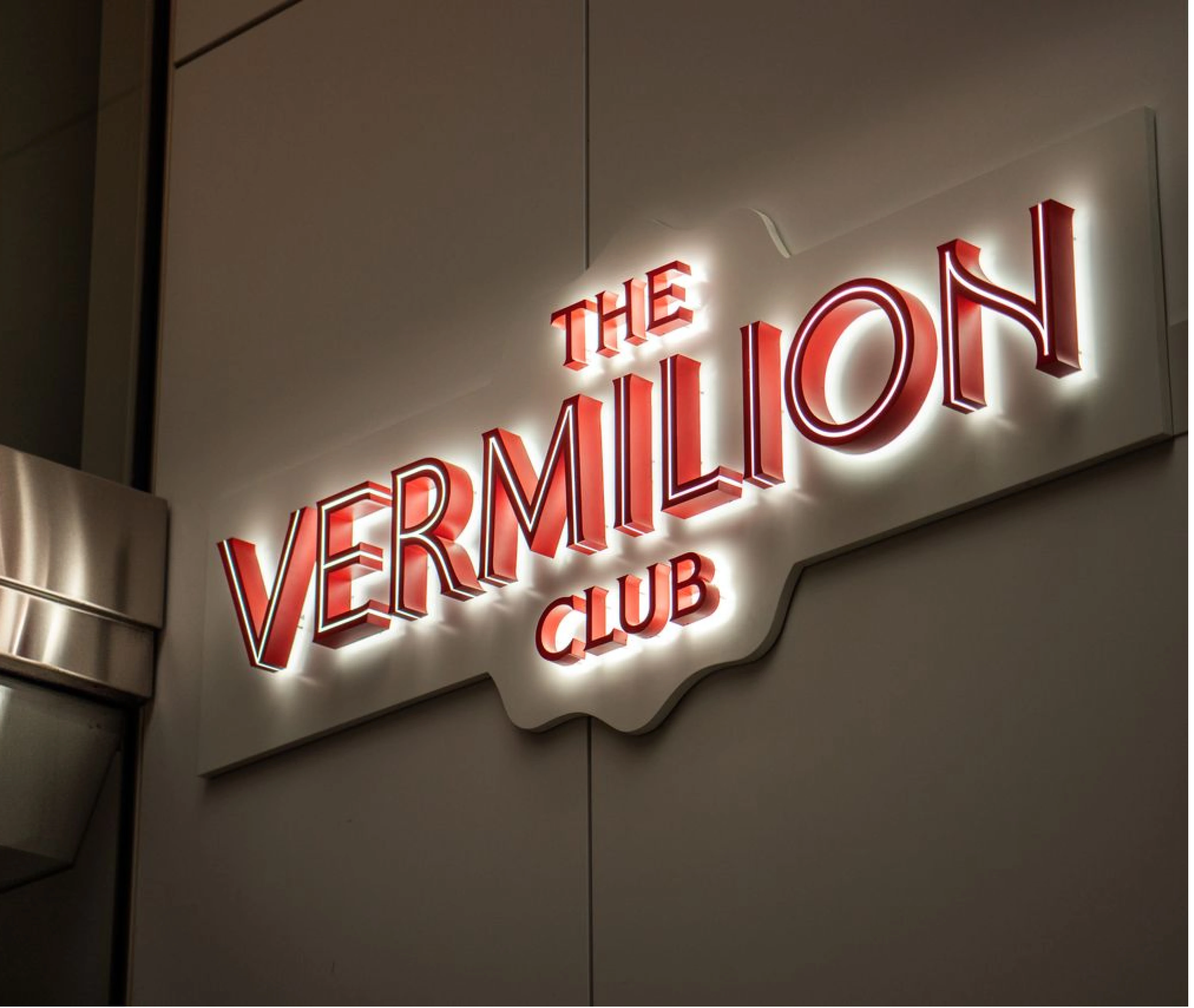 Exterior sign of The Vermilion Club illuminated at night