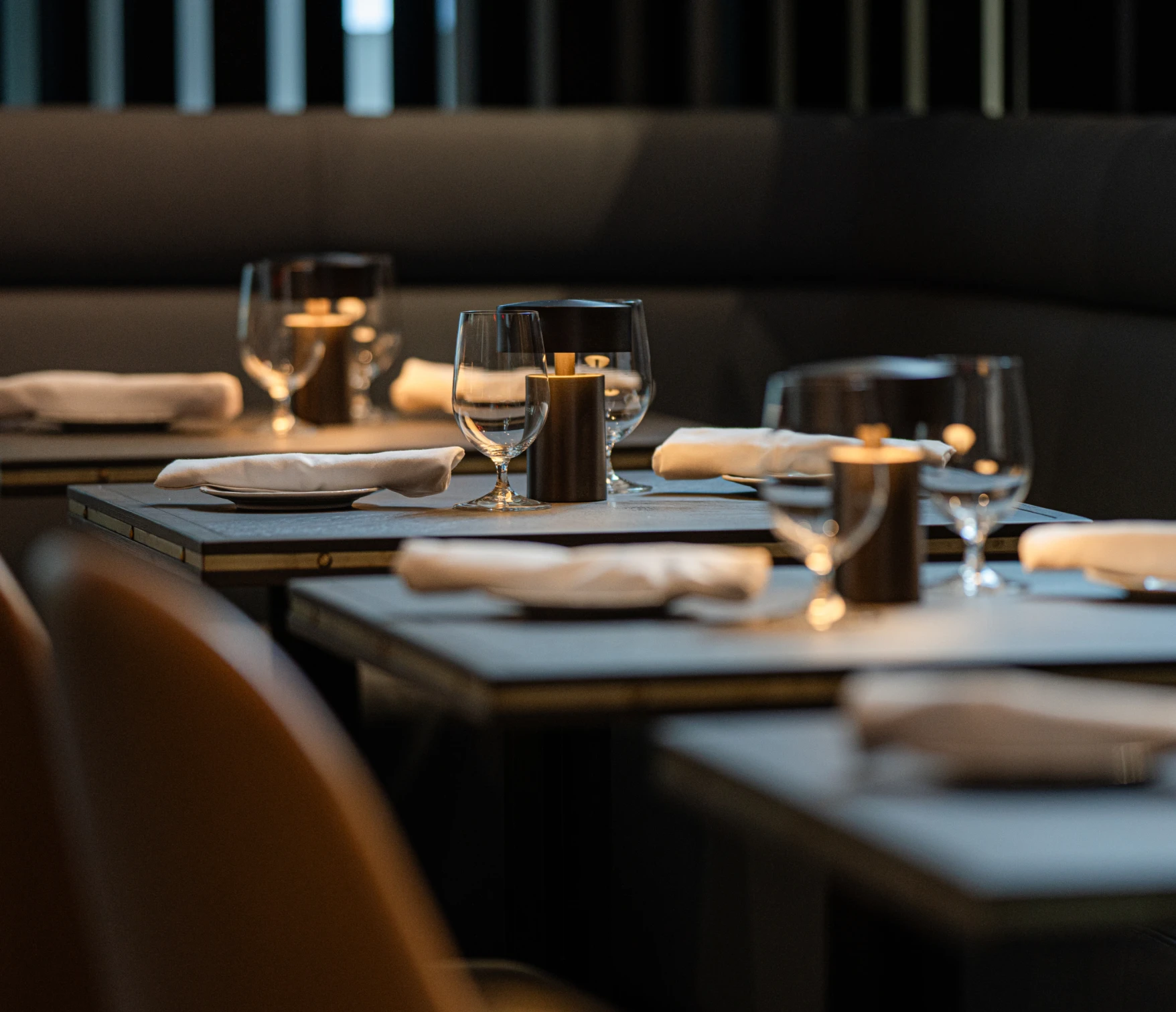 Elegant table setting with glassware, napkins, and soft candlelight inside The Federal Room at The Vermilion Club.
