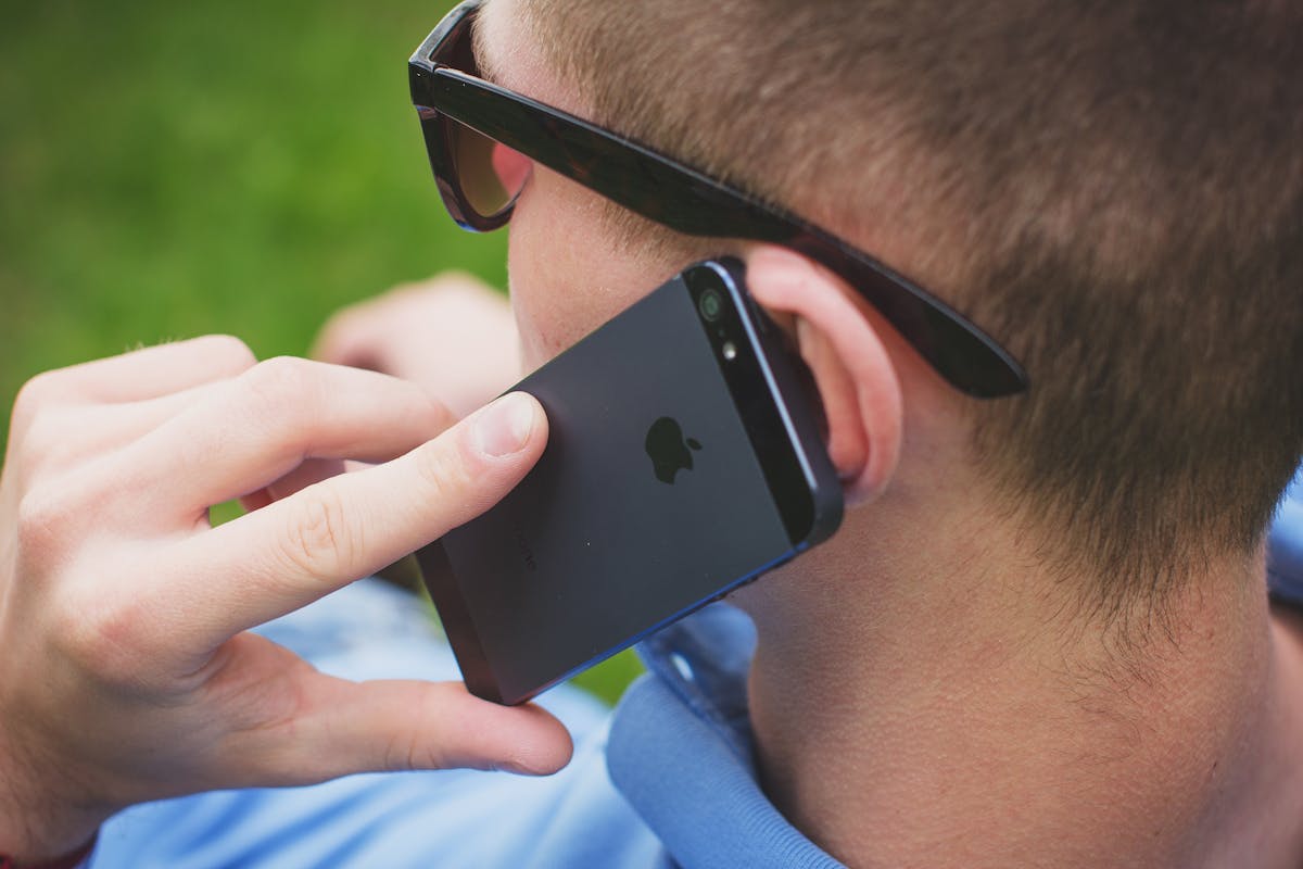 a man wearing glasses talking on a cell phone