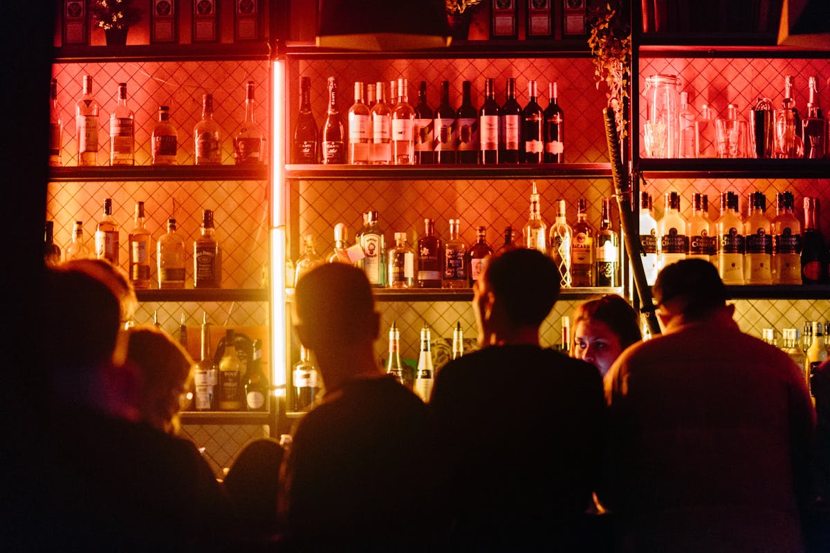 a group of people standing in front of a bar