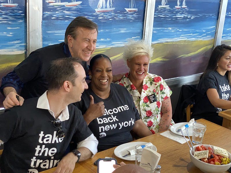 Daniel Boulud, Anne Burrell sitting at a table with food and water
