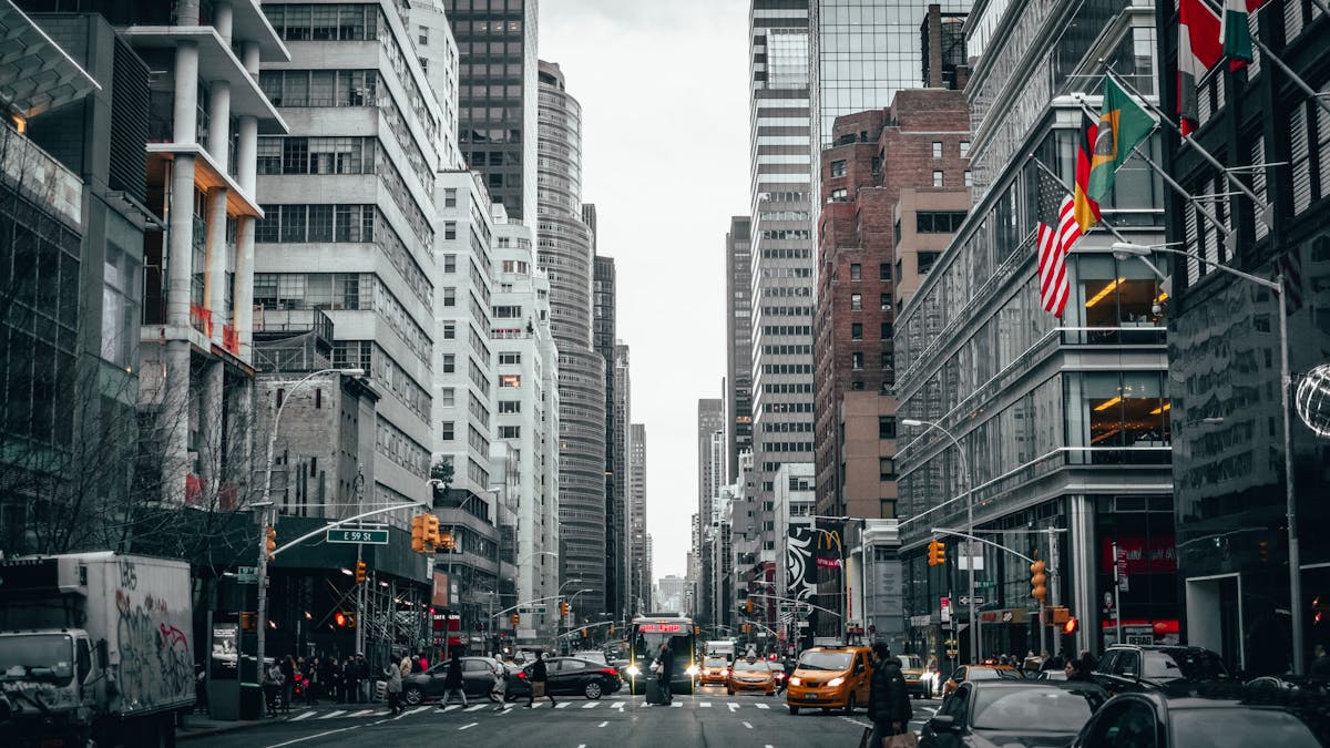 a city street filled with traffic surrounded by tall buildings