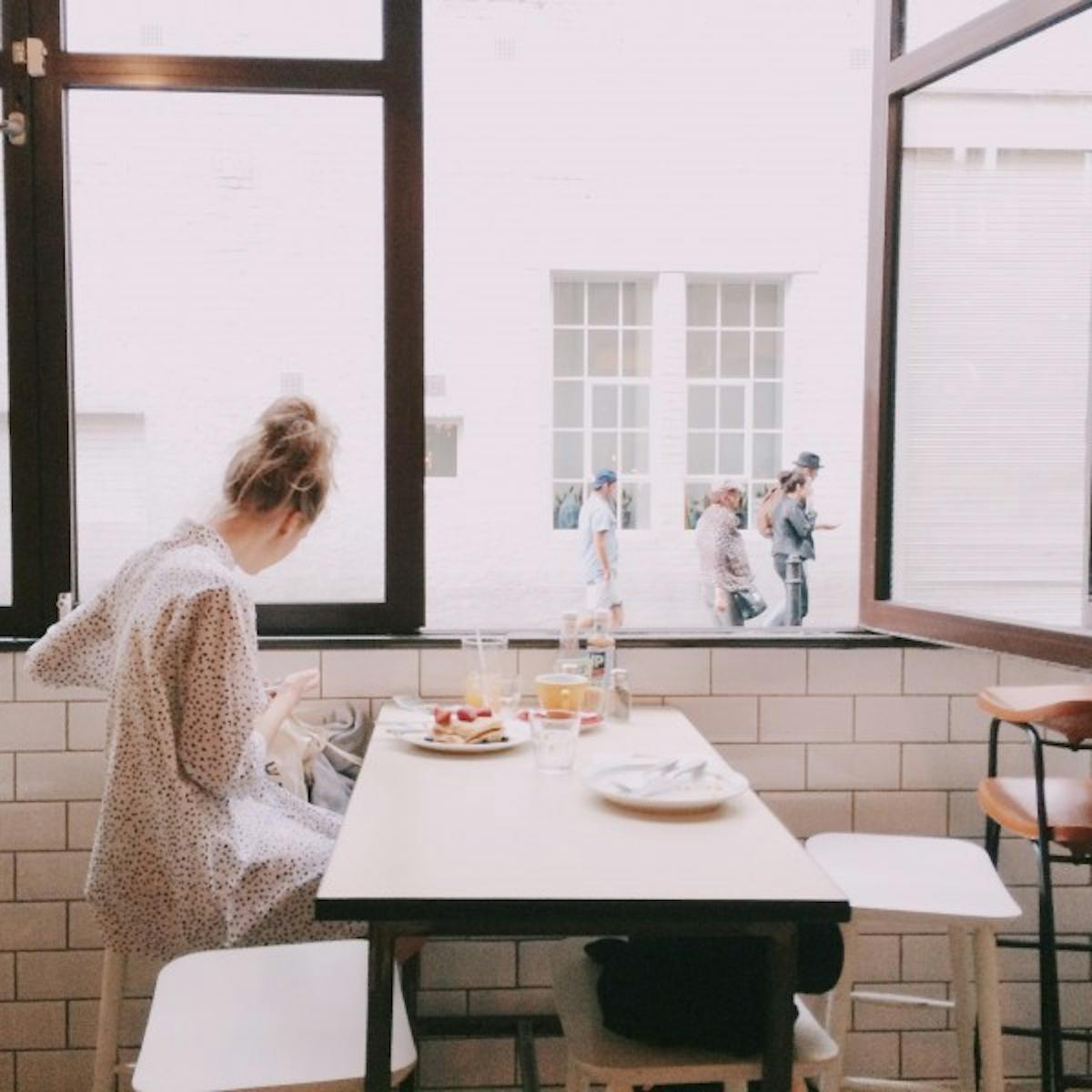 a person sitting at a table in front of a window