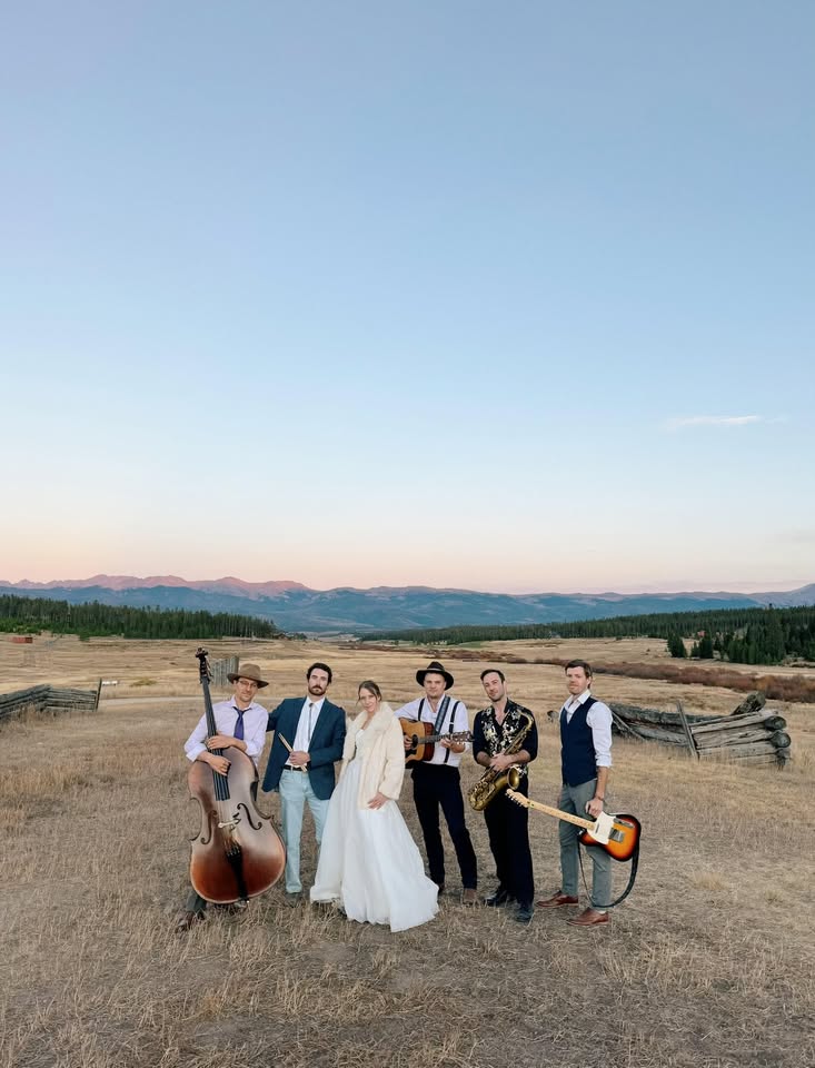 a group of people standing on top of a dirt field