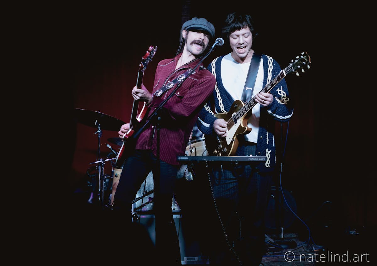 Two guys playing guitar