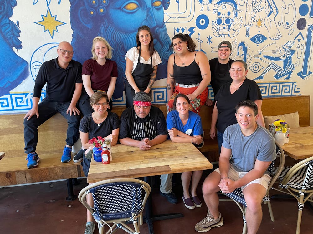 a group of people sitting on a bench posing for the camera