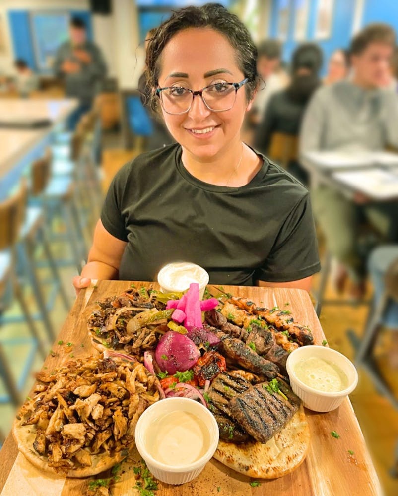 a person sitting at a table with a plate of food