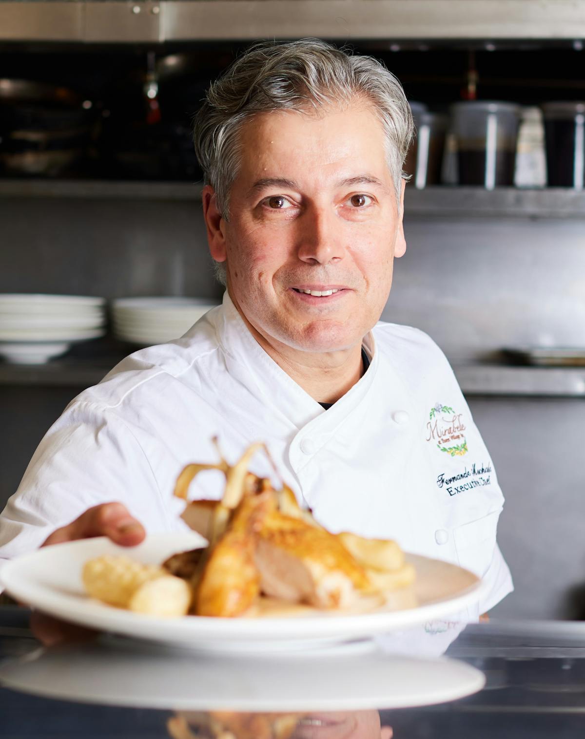 A chef holding  a plate of fine dining