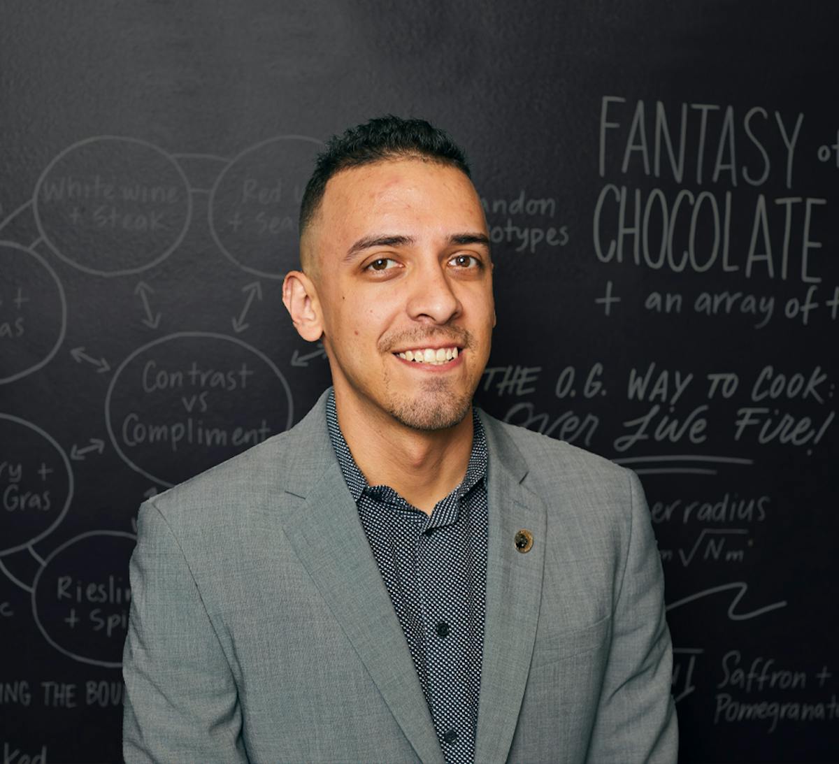 a man standing in front of a blackboard