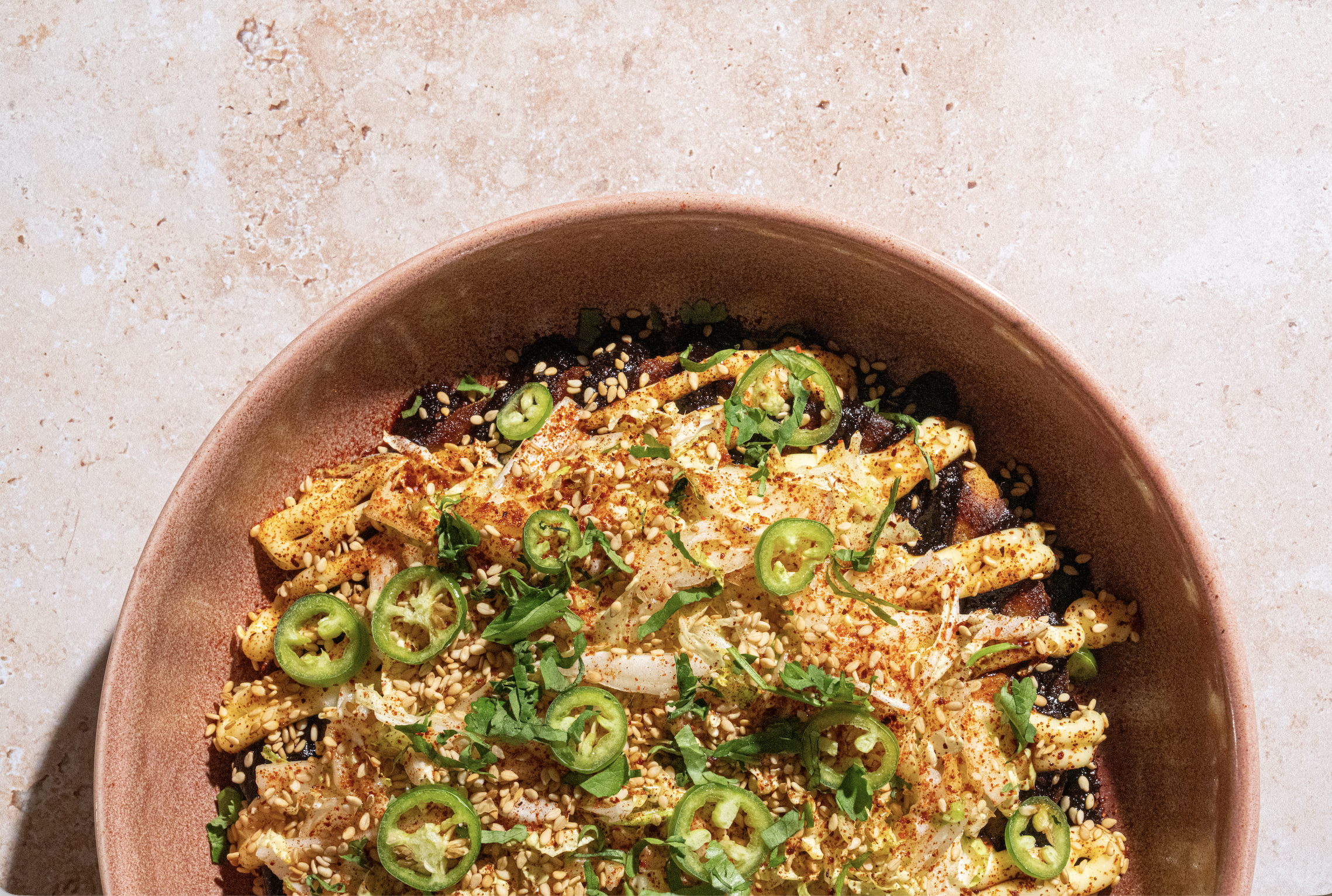 a bowl of food with jalapenos and sesame seeds