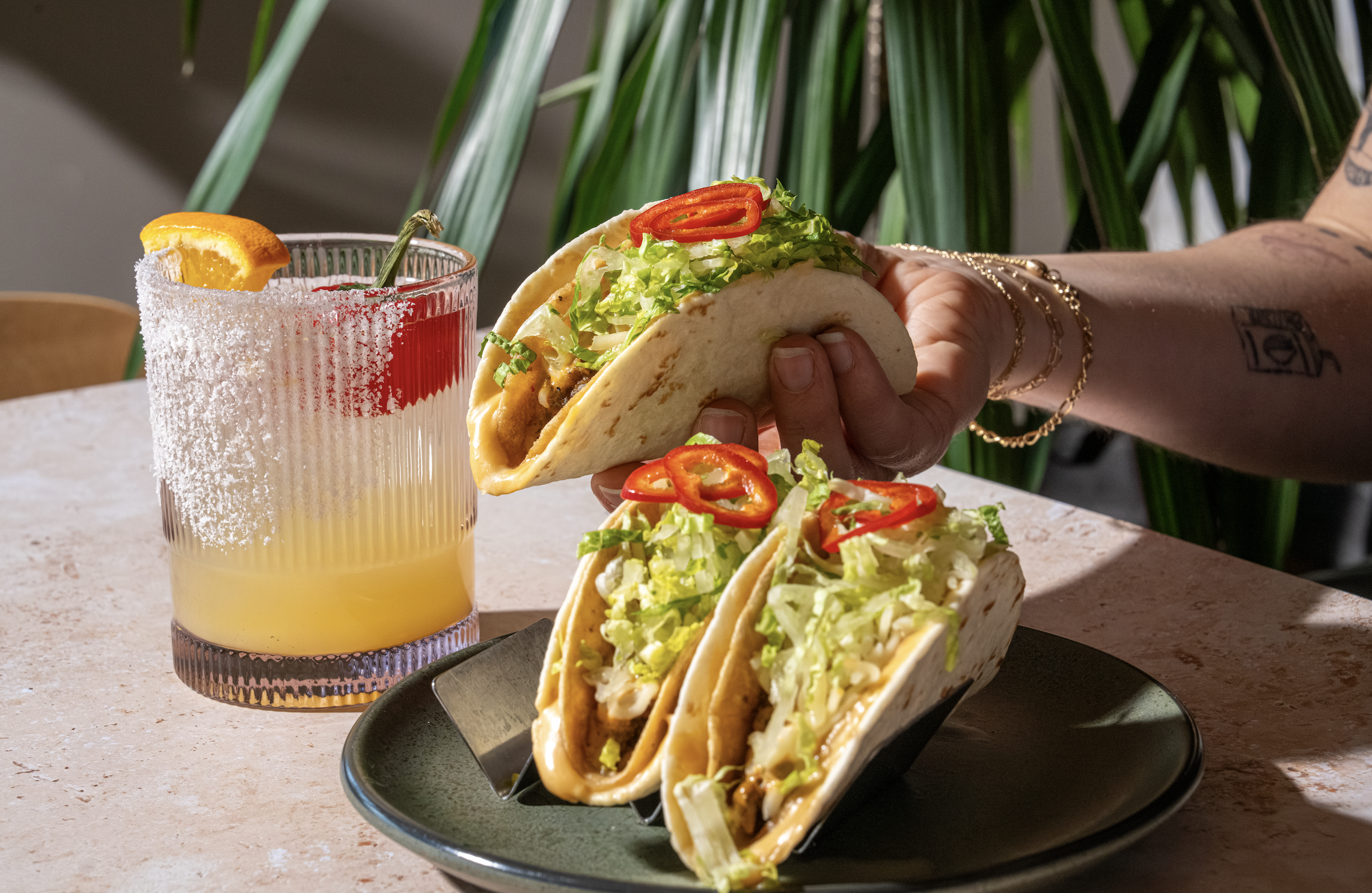 a person holding a taco on a plate