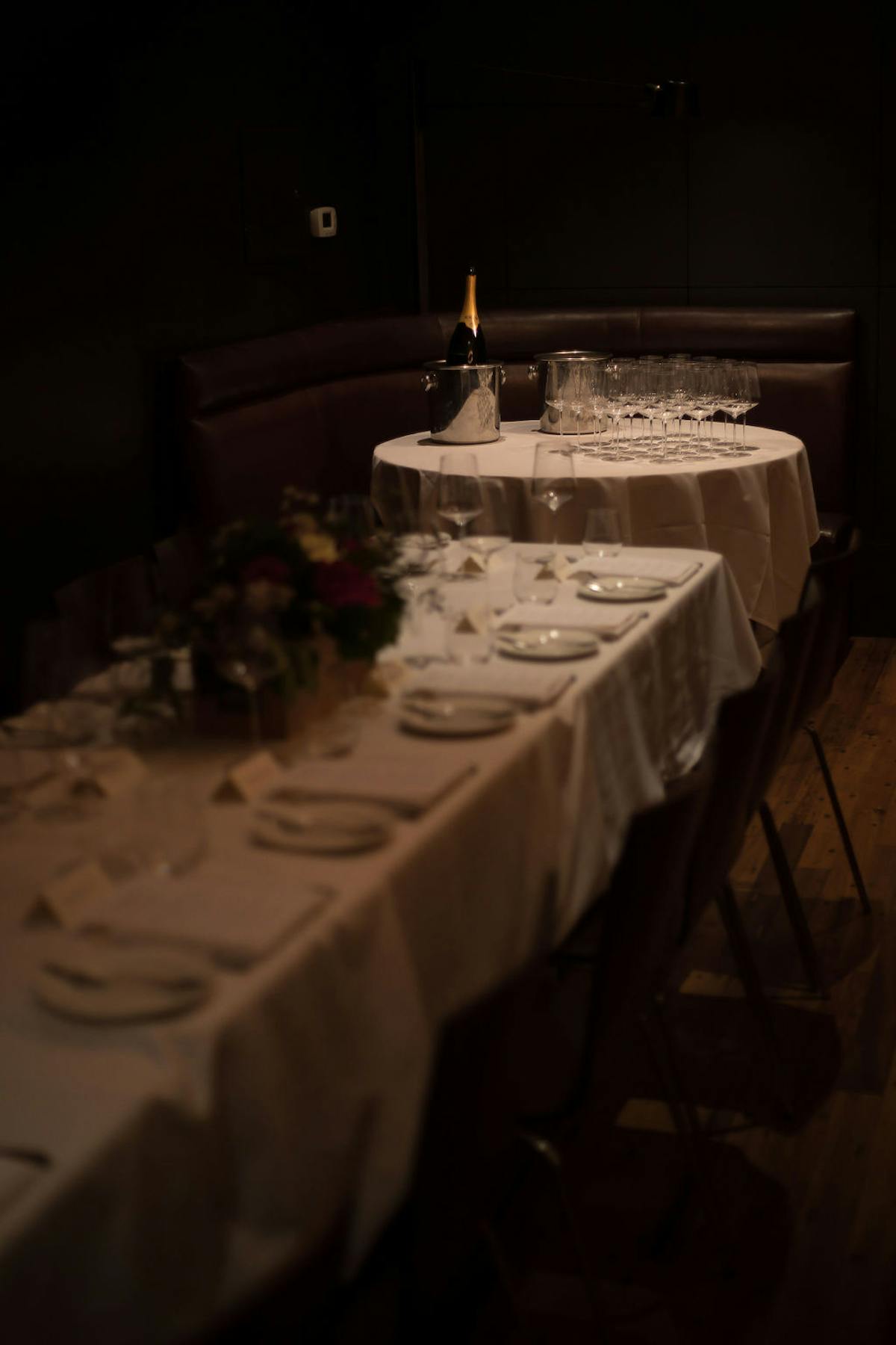 a large dining table with cups and plates and a flower pot in the middle