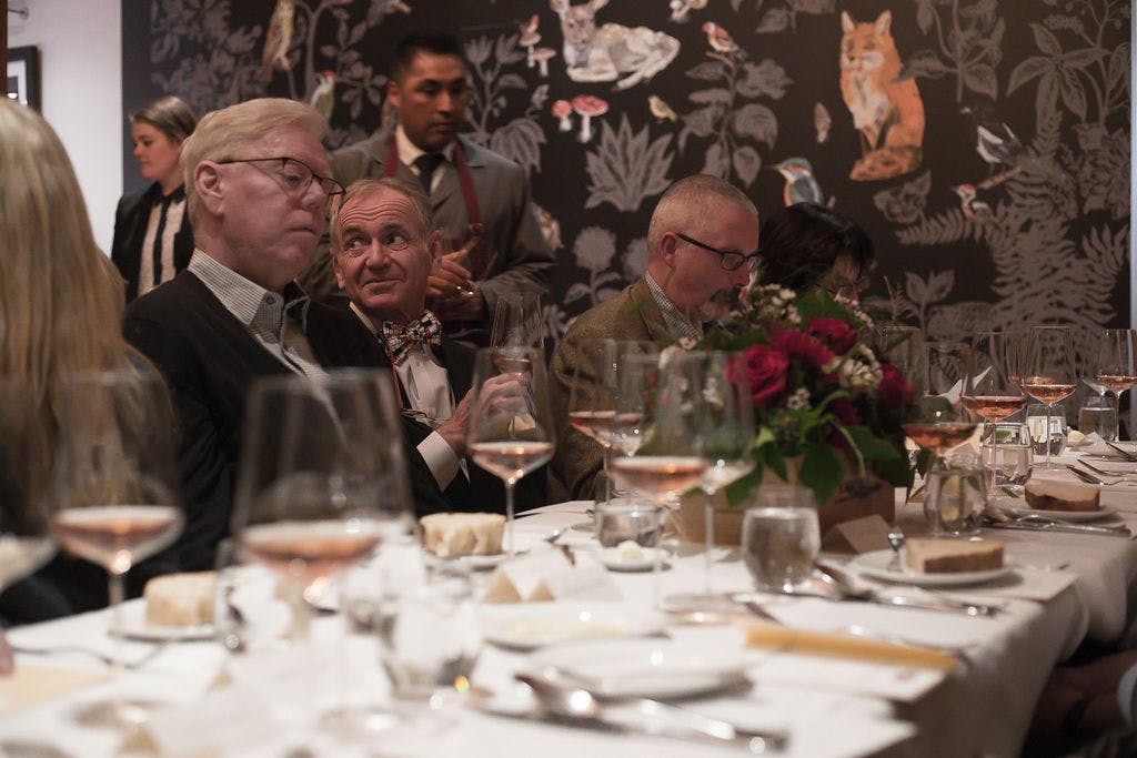 a group of people sitting at a table with wine glasses