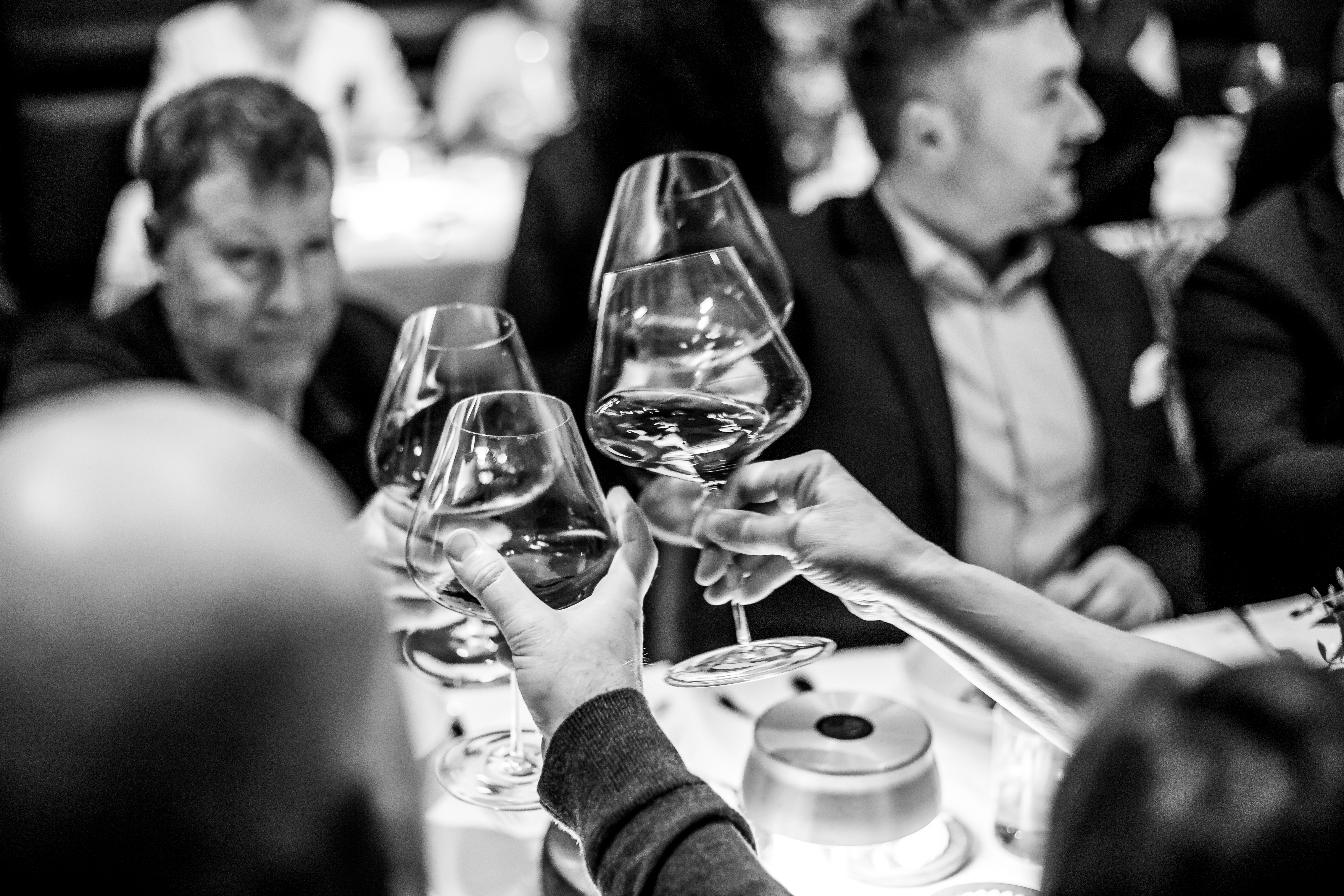 a group of people sitting at a table with wine glasses