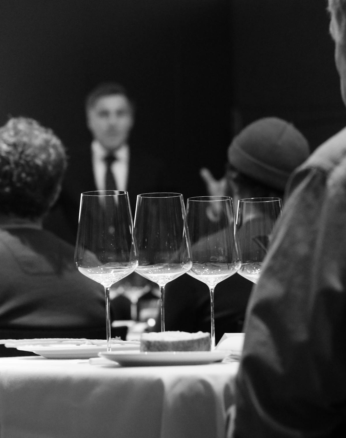 a person sitting at a table with wine glasses