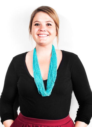 a woman with a large necklace posing for the camera