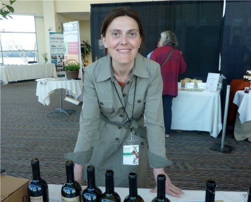 a person standing next to a bottle of wine